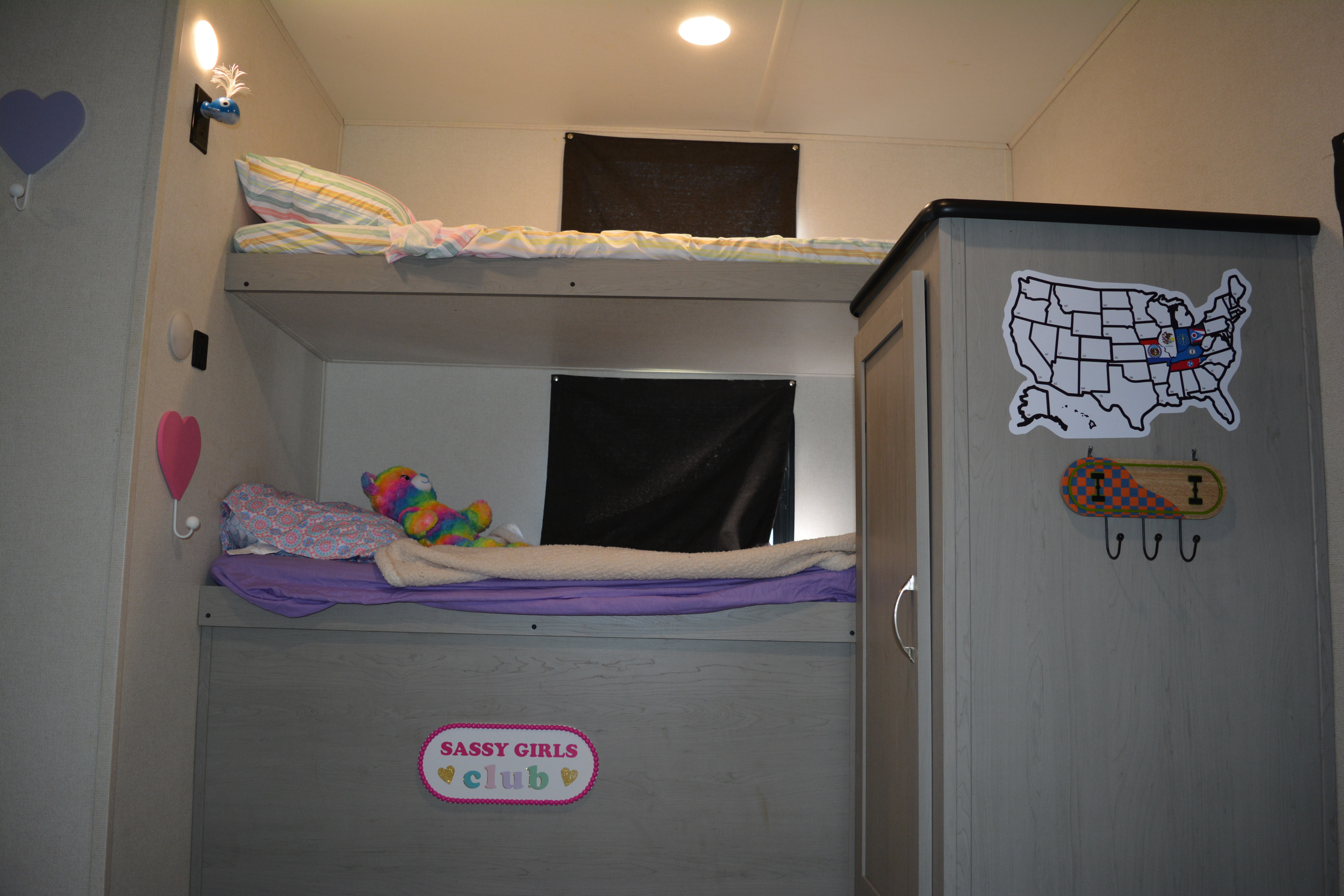 Cozy bunk beds in an RV rental, decorated with hearts, a USA map, and a "Sassy Girls Club" sign, perfect for kids' travel.. Forest River Tracer 2023