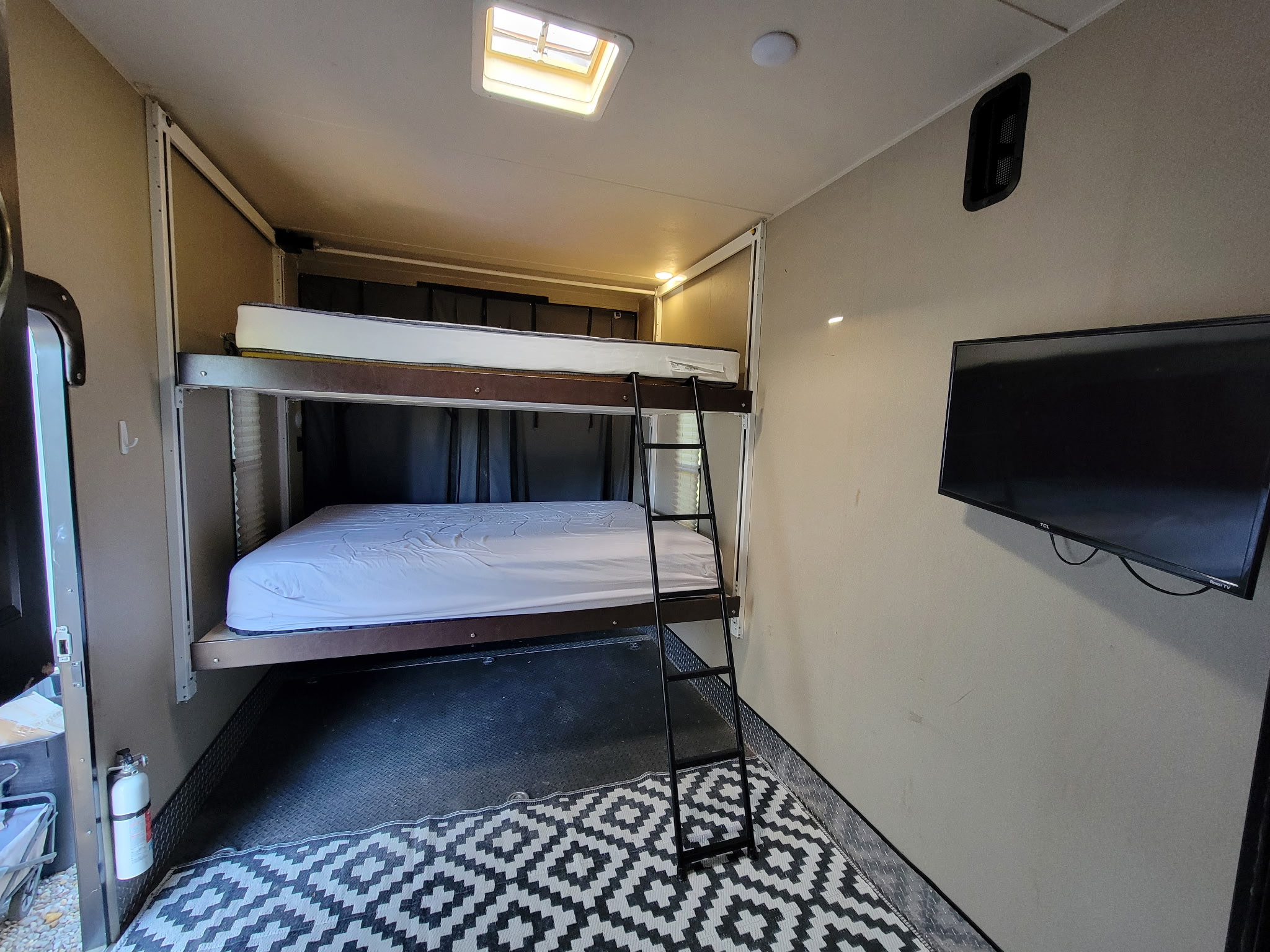RV rental interior: bunk beds with ladder, TV, and skylight. Features a cozy sleeping area for your travels.. Heartland RVs Prowler Toy Hauler 2017