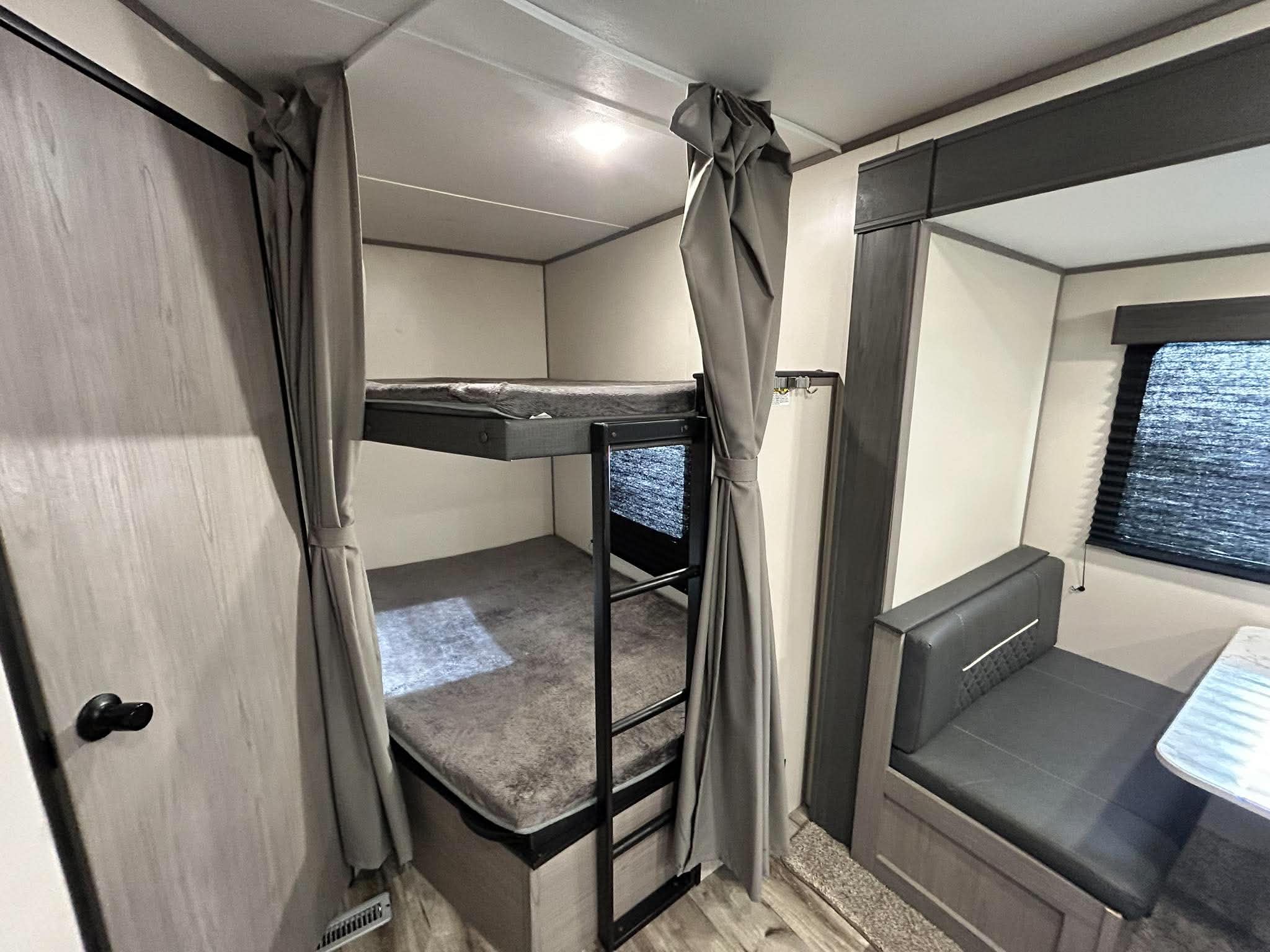 This RV rental offers a cozy bunk bed setup with privacy curtains and a dinette area. Ideal for family travel, enjoy comfort on the road.. Other Other 2022