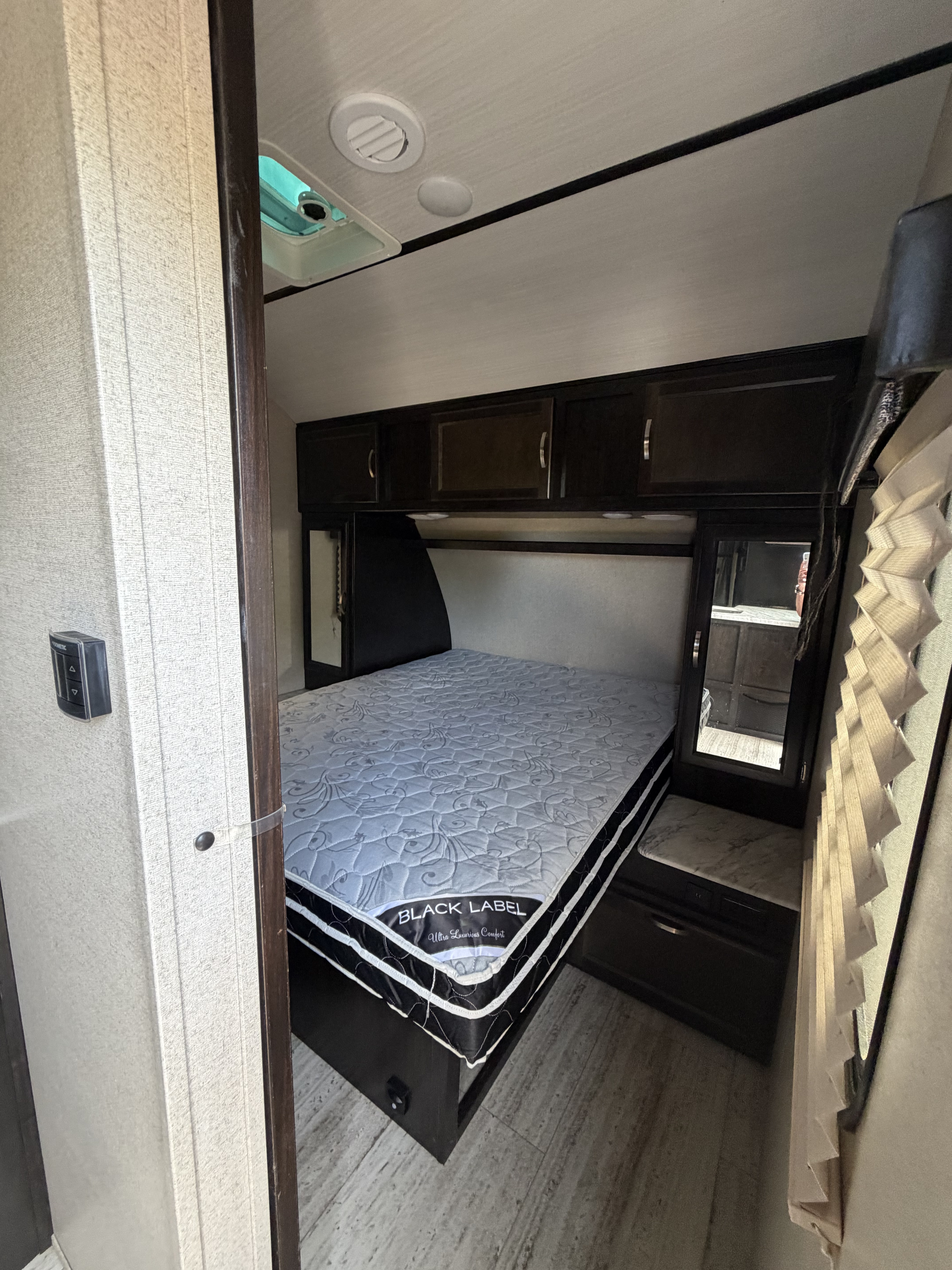 Experience comfort in this RV rental bedroom, featuring a "BLACK LABEL" mattress, overhead cabinets, and climate control.. Coachmen Spirit Lite Ultra 2963BH 2020