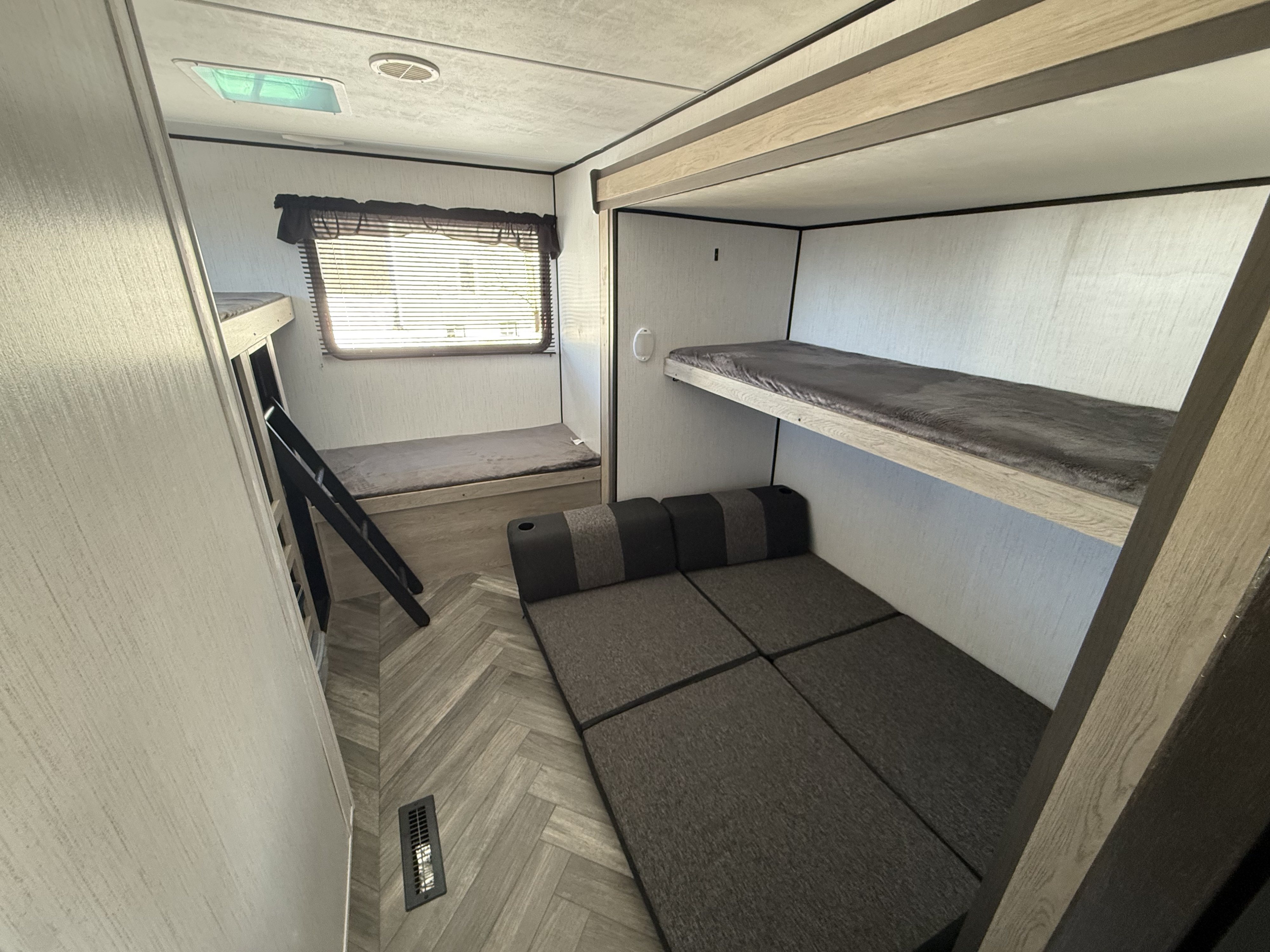 RV rental bunk room: multiple sleeping options including fixed bunk beds, a lower bed with ladder, and a convertible sofa.. Heartland RVs Prowler 2022