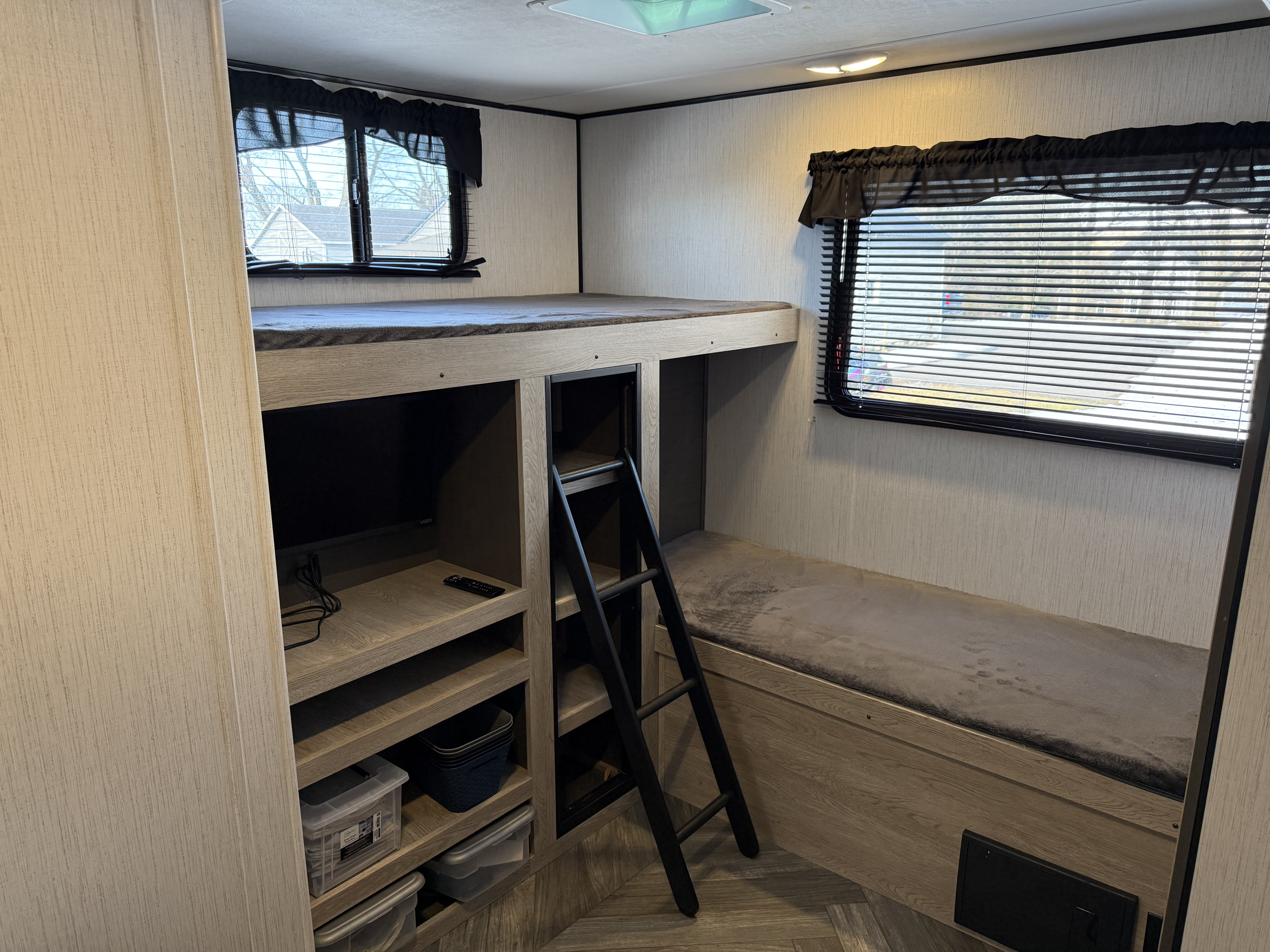 RV rental bunk beds with TV, built-in storage, and windows. This cozy camper space is ready for your family's next adventure!. Heartland RVs Prowler 2022