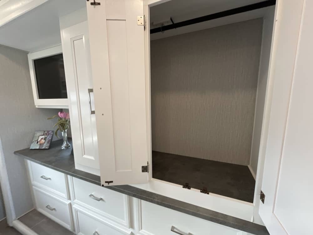 RV rental: Open closet with hanging rod for clothes storage, white cabinets, and dark countertop.. Forest River Coachmen Mirada 2023