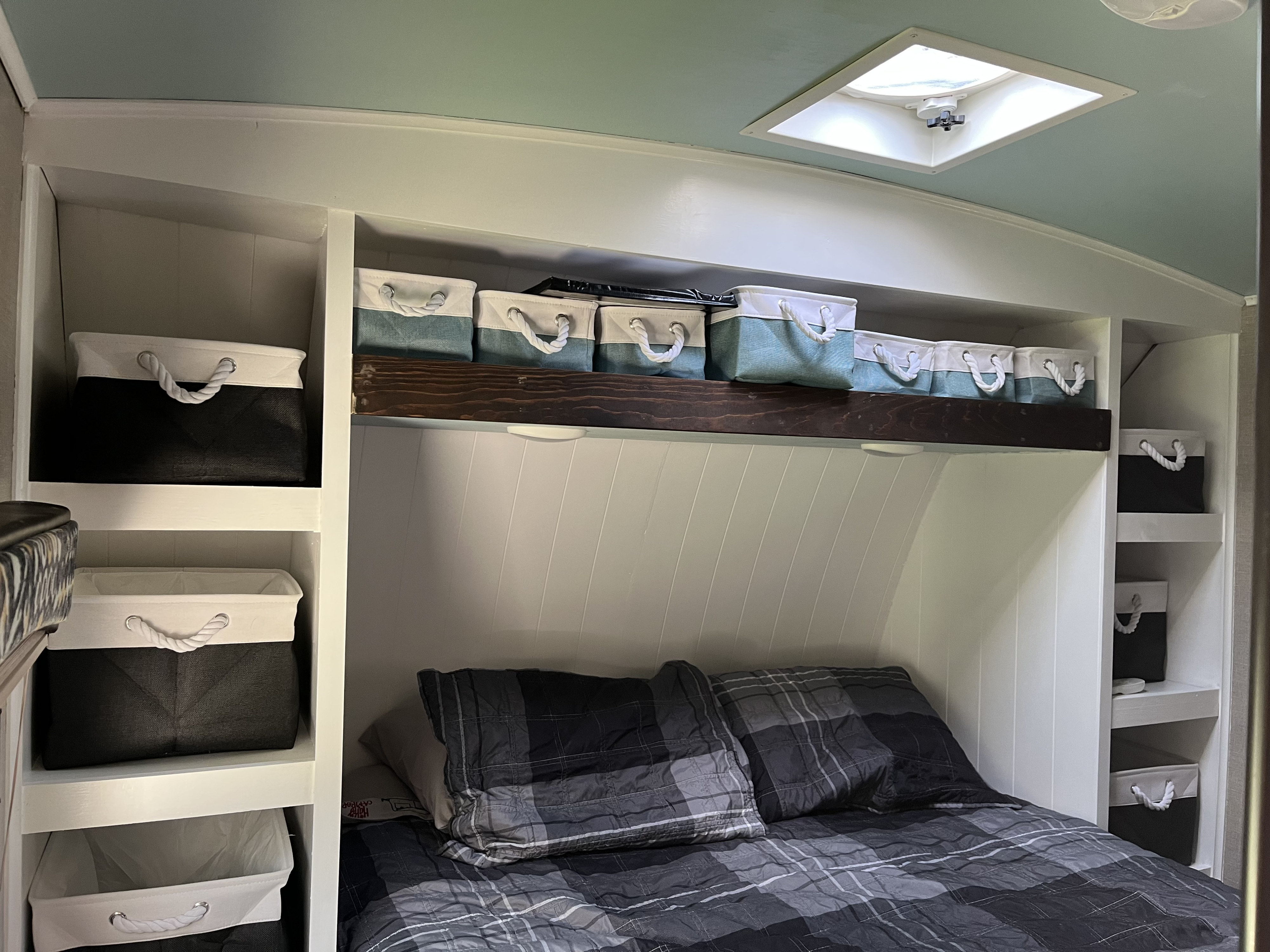Neat RV rental bedroom showcasing smart storage with fabric bins, a comfortable plaid bed, and a skylight overhead for bright travel.. Cruiser RV Fun Finder Xtreme Lite 2017