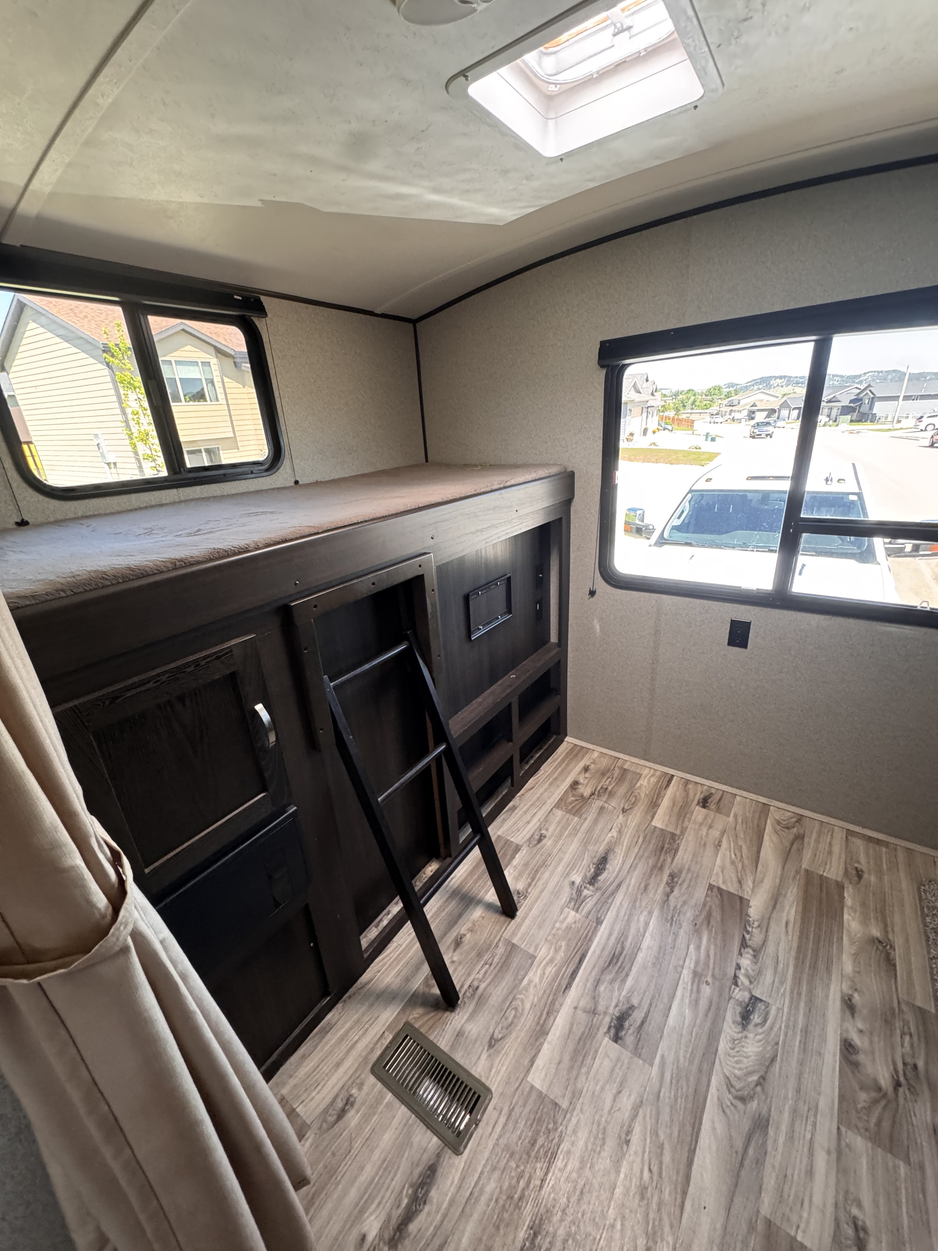 Interior of an RV rental: Bunk bed with ladder, skylight, and windows for your family's trip.. Keystone RV Springdale 2019