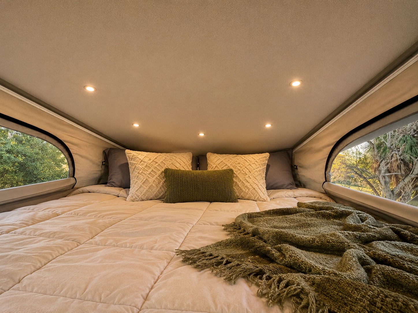 Cozy pop-top RV rental bedroom with a plush bed, pillows, and ambient lighting. Enjoy nature views from large windows.. Jayco Swift 2024