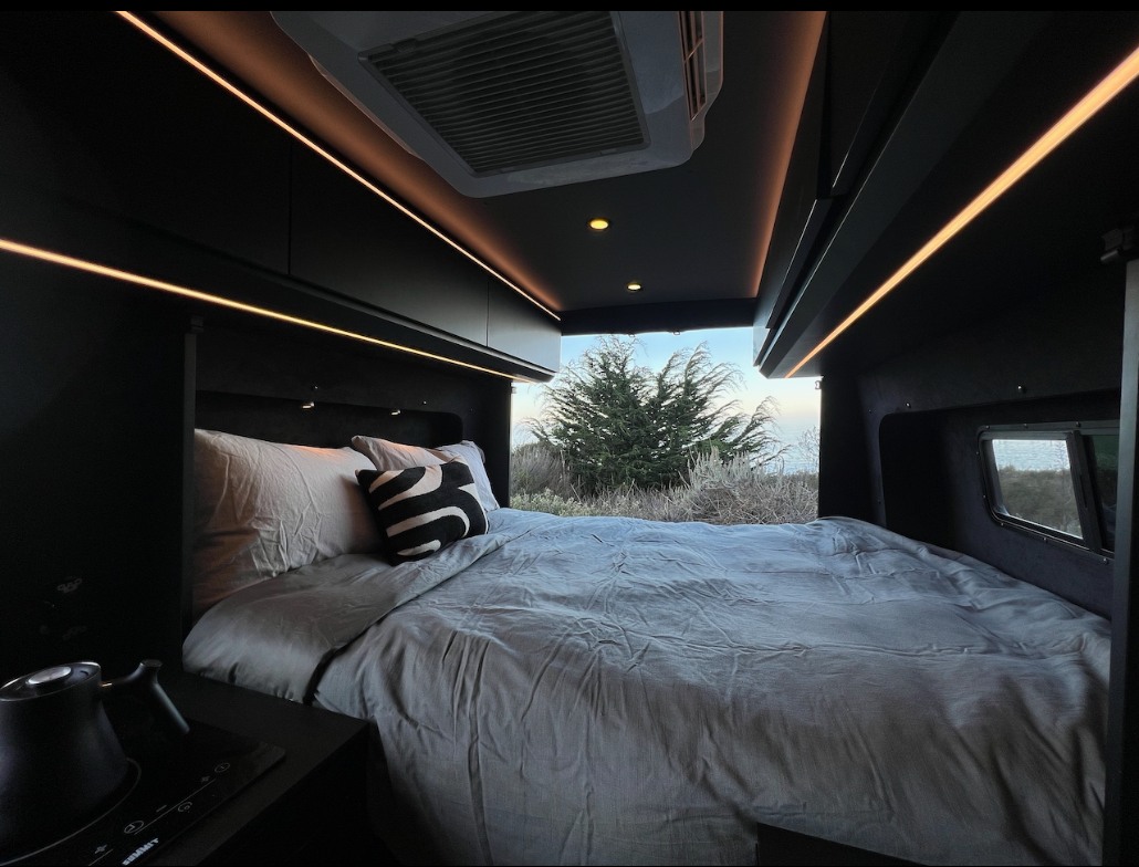 RV rental's cozy bedroom. A comfortable bed, warm strip lighting, and a window view to nature.. Mercedes Sprinter 144 2020