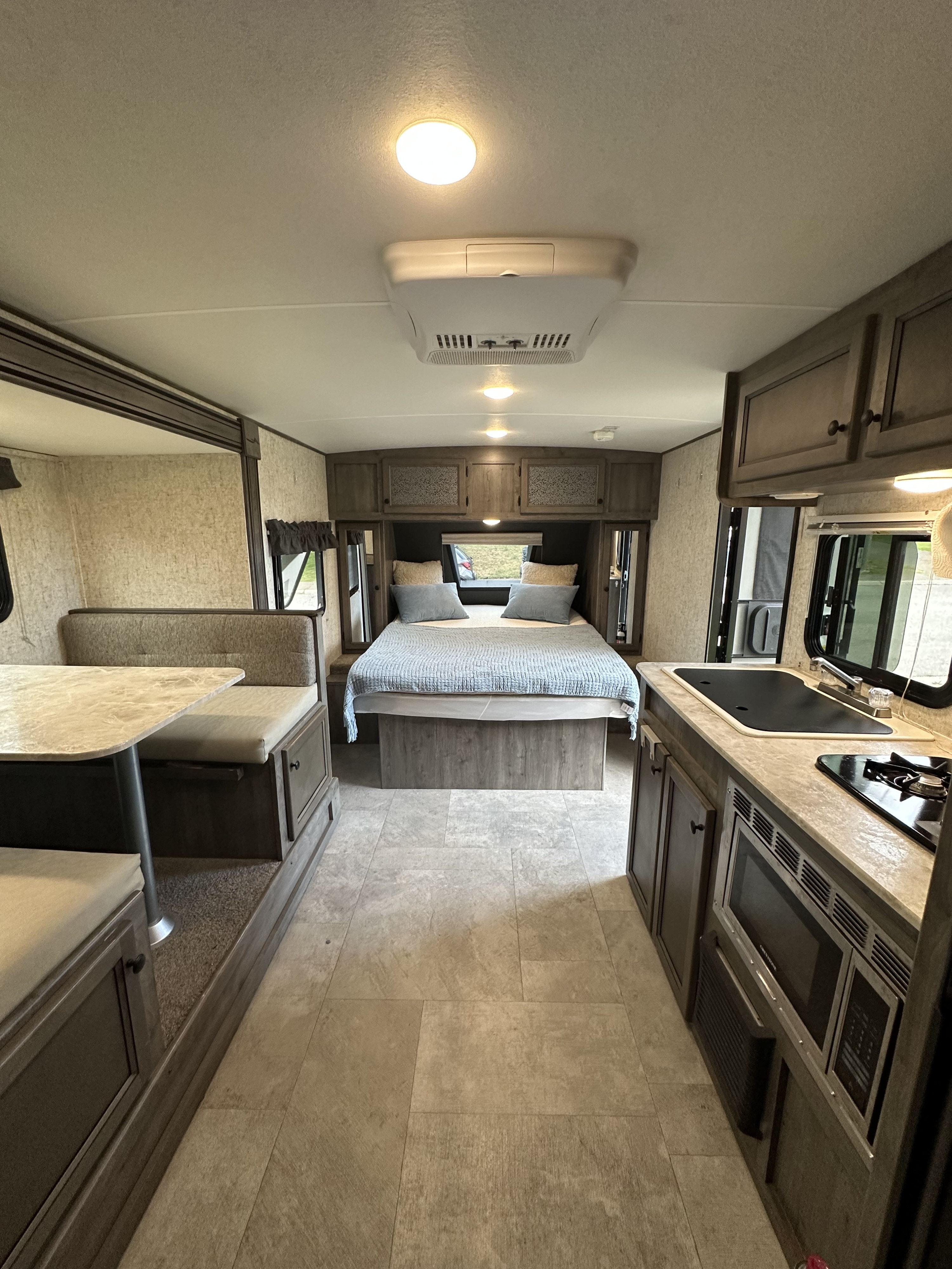 This RV rental interior offers a comfortable bedroom, kitchen area, and dinette. Ideal for your next road trip.. Coachmen Apex Nano 2020