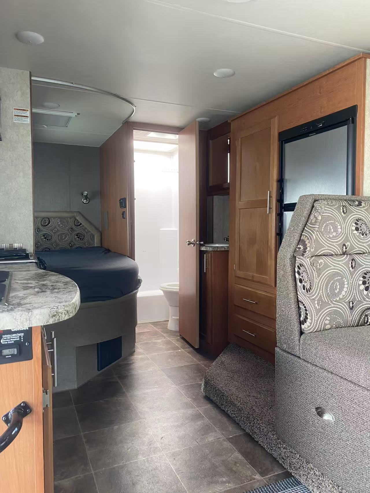 This RV rental interior offers a comfortable bed, bathroom, kitchen with stovetop, and seating area for your travel adventures.. Adventurer Adventurer Motorhome 2016