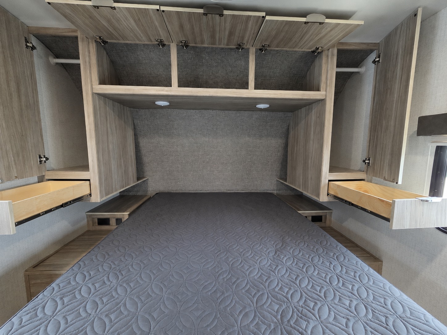 RV rental bedroom features a bed, overhead cabinets, wardrobes, and bedside storage for compact living.. Minnie Minnie Trailer 2022