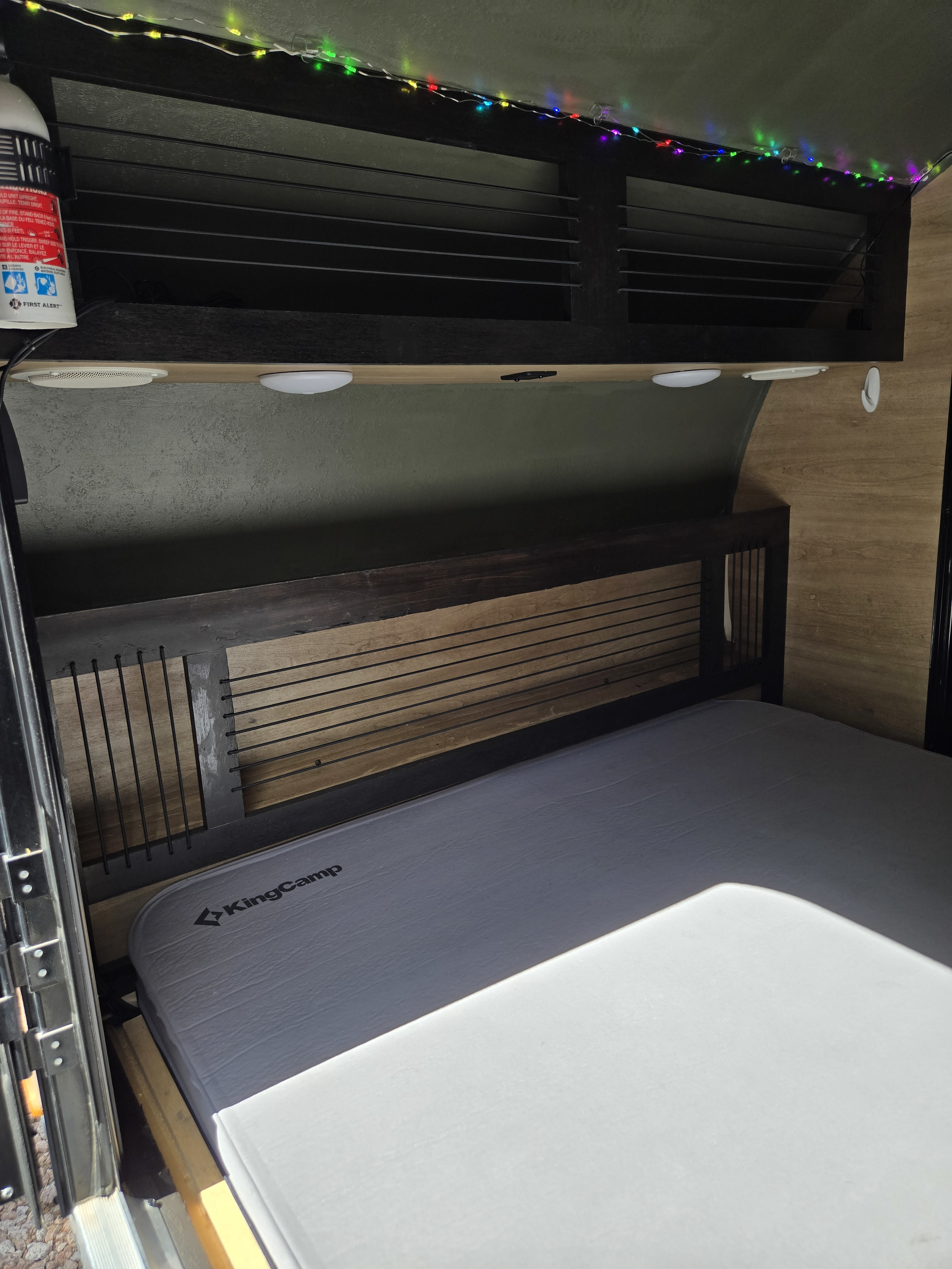 RV rental: KingCamp mattress, slatted headboard, overhead storage with colorful string lights & First Alert extinguisher.. Braxton Creek Bushwhacker 2021