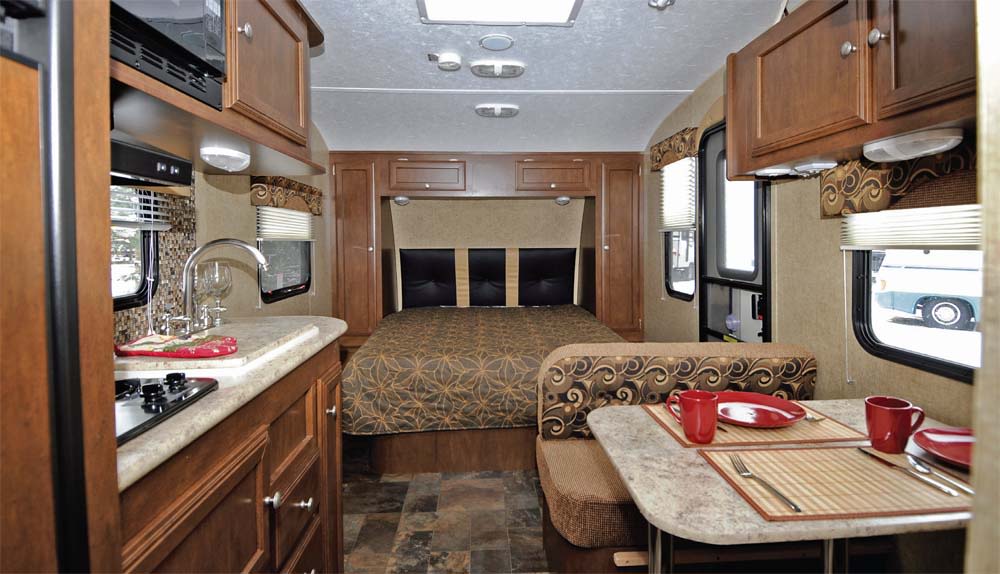 Spacious RV rental interior with a cozy bedroom, fully equipped kitchen, and dining area for comfortable travel.. Sonic Sonic Trailer 2014