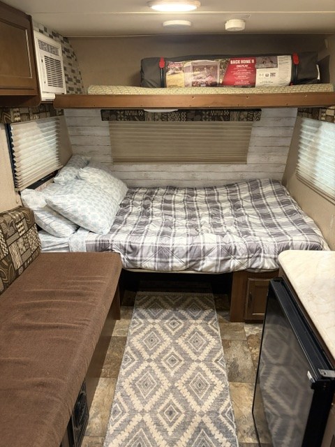 RV rental interior featuring a cozy bed, bunk, dinette, and small fridge.. Jayco Jay Flight SLX 2015