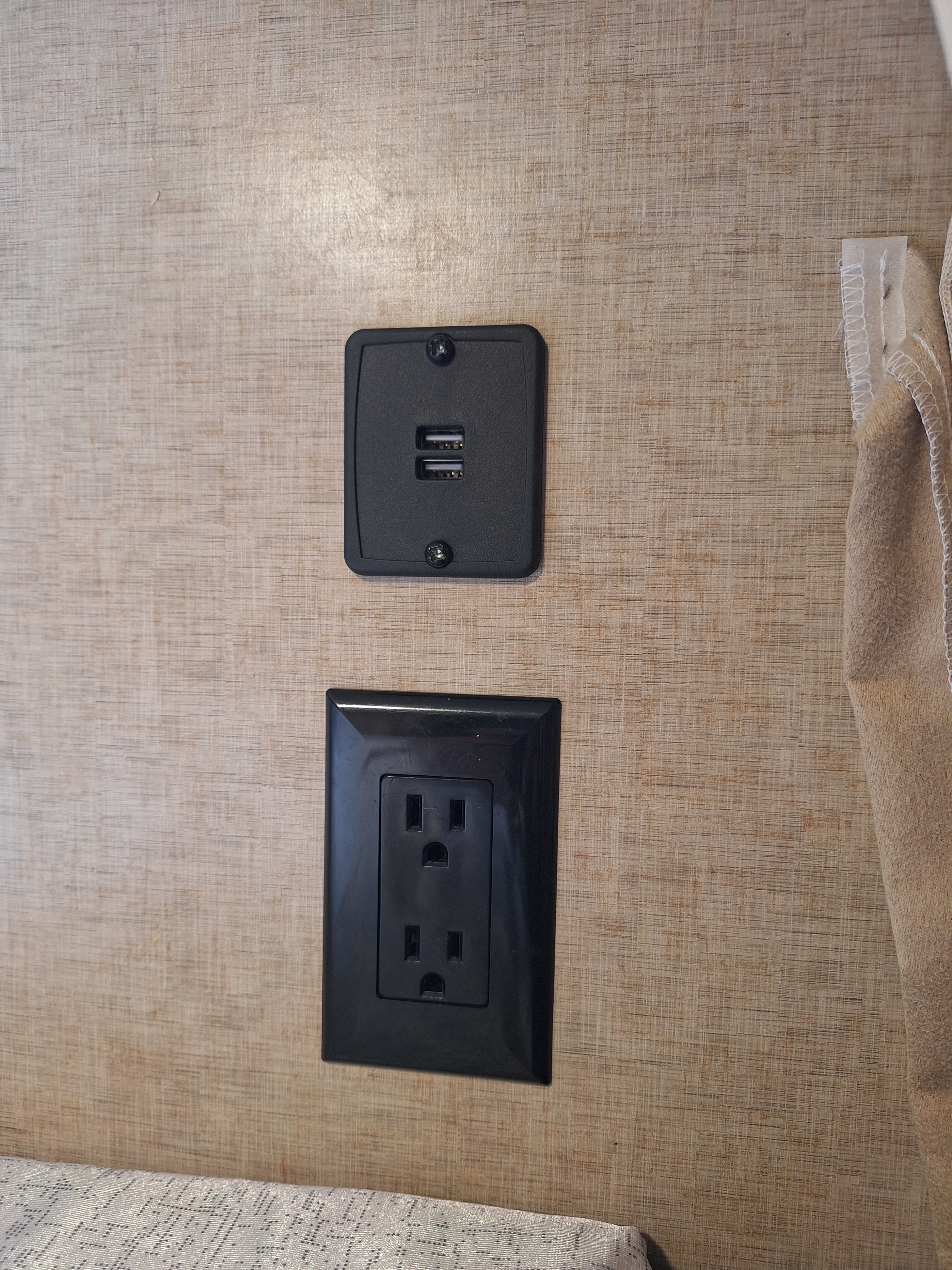 RV rental wall featuring dual USB charging ports and a standard AC power outlet, mounted on a textured beige surface.. Forest River Cherokee 2018