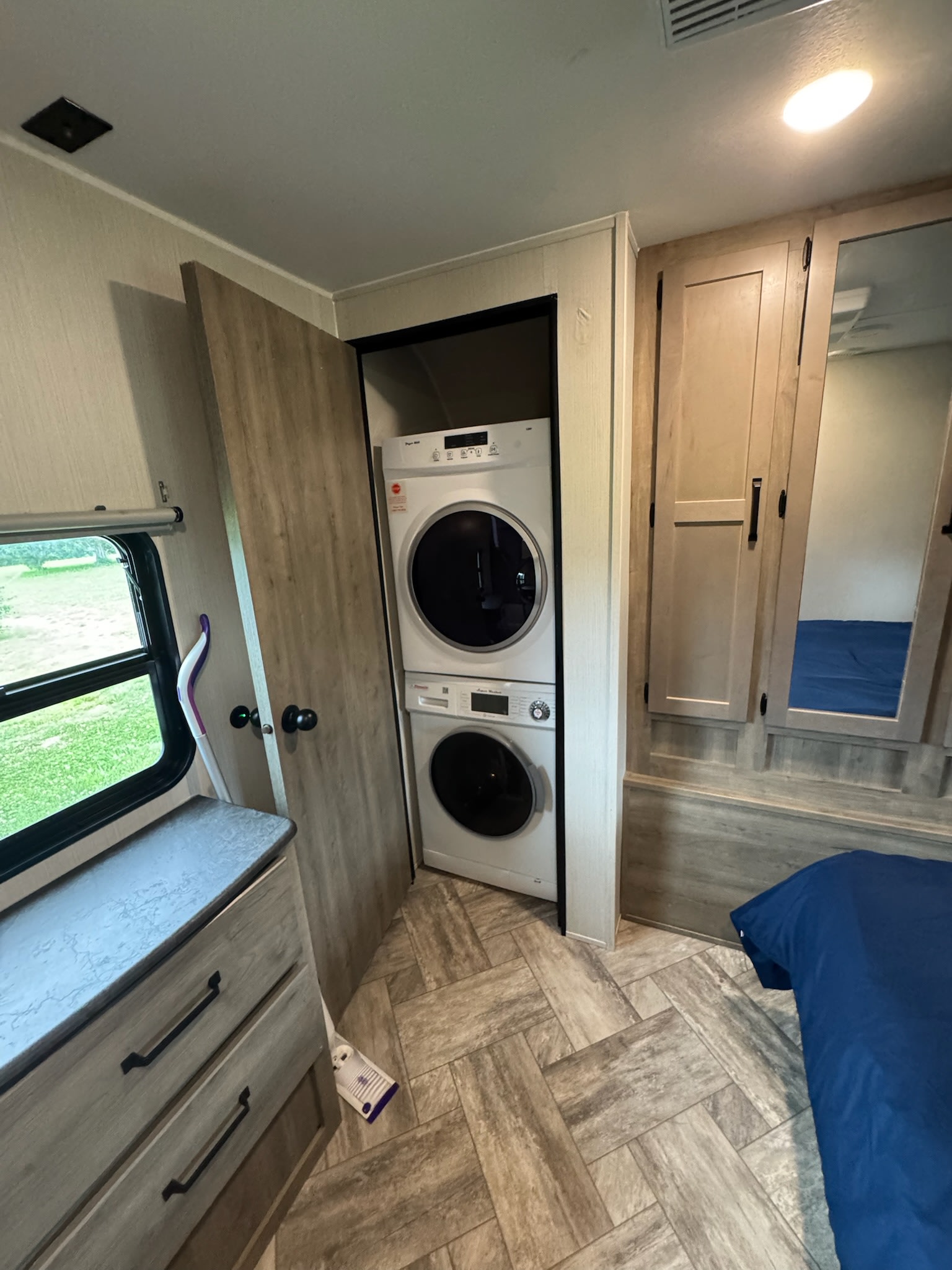 RV rental interior: bedroom with stackable washer/dryer, dresser, bed, and mirrored storage. Modern and convenient.. Forest River Palomino Puma 2023