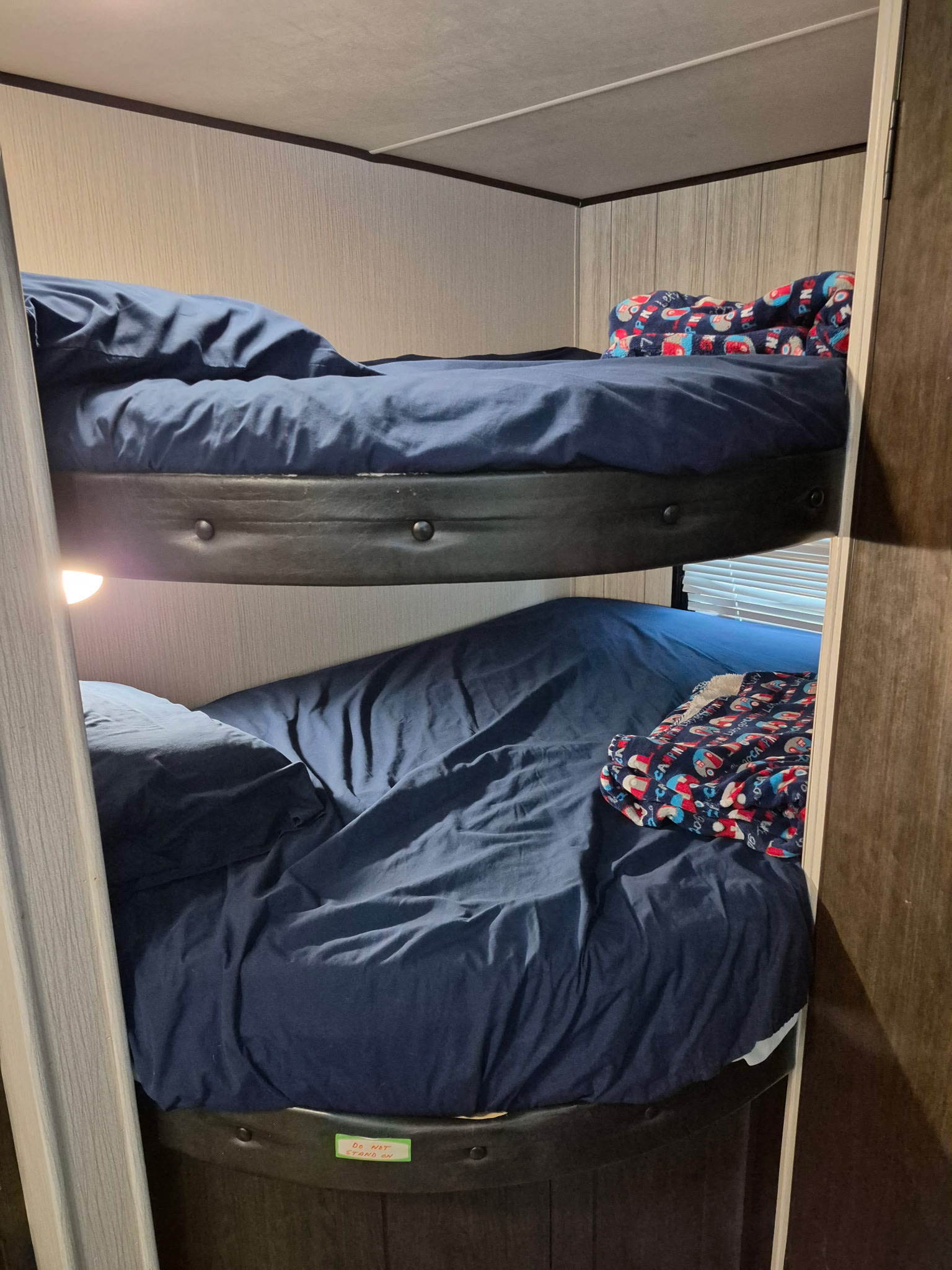 Inside this RV rental, two cozy bunk beds with blue bedding and colorful blankets offer a comfortable sleeping area for your trip.. Heartland Pioneer 2021