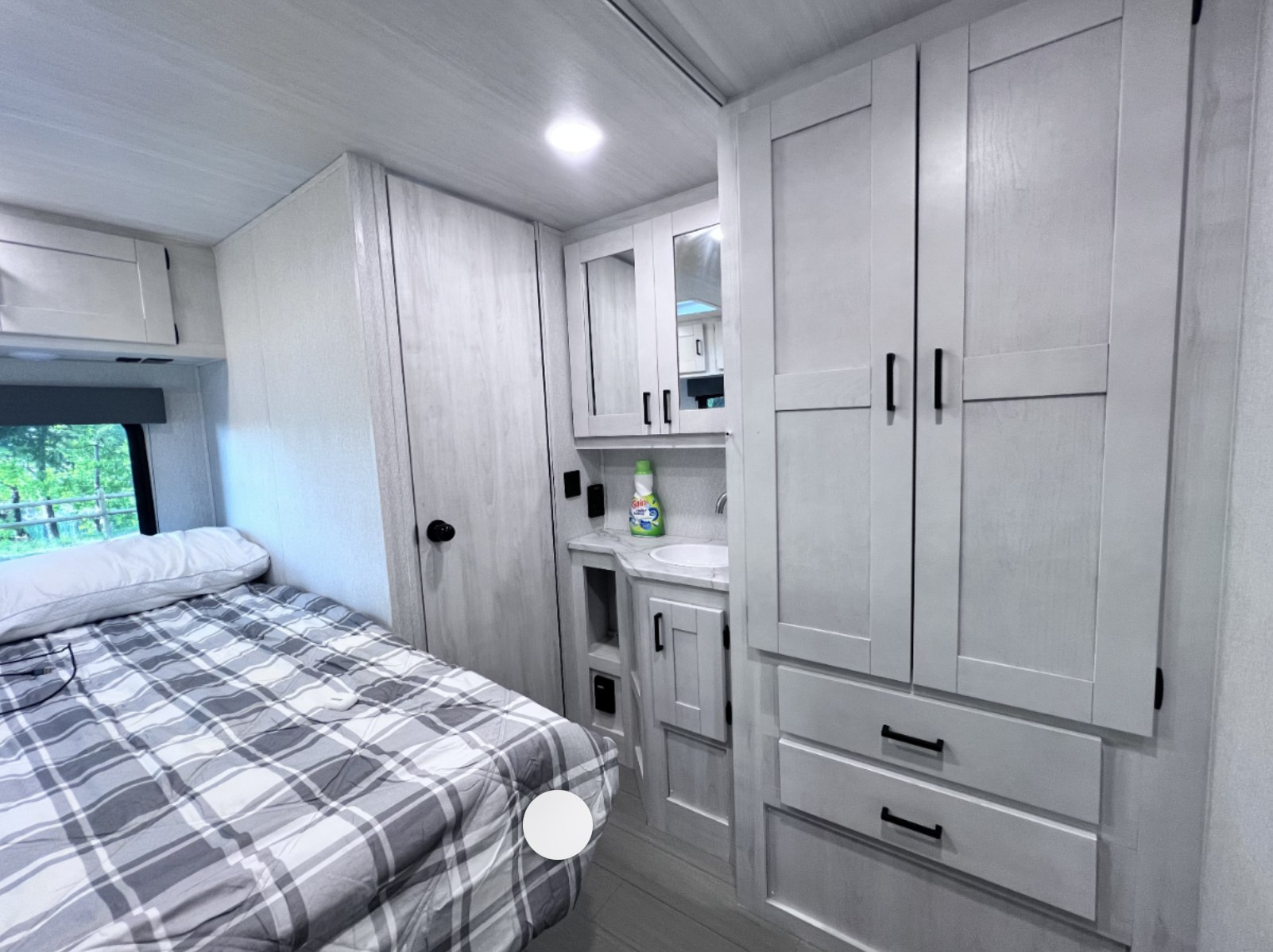 RV rental interior featuring a modern bedroom, compact vanity, and ample storage solutions for comfortable travel.. East to West Entrada 2026