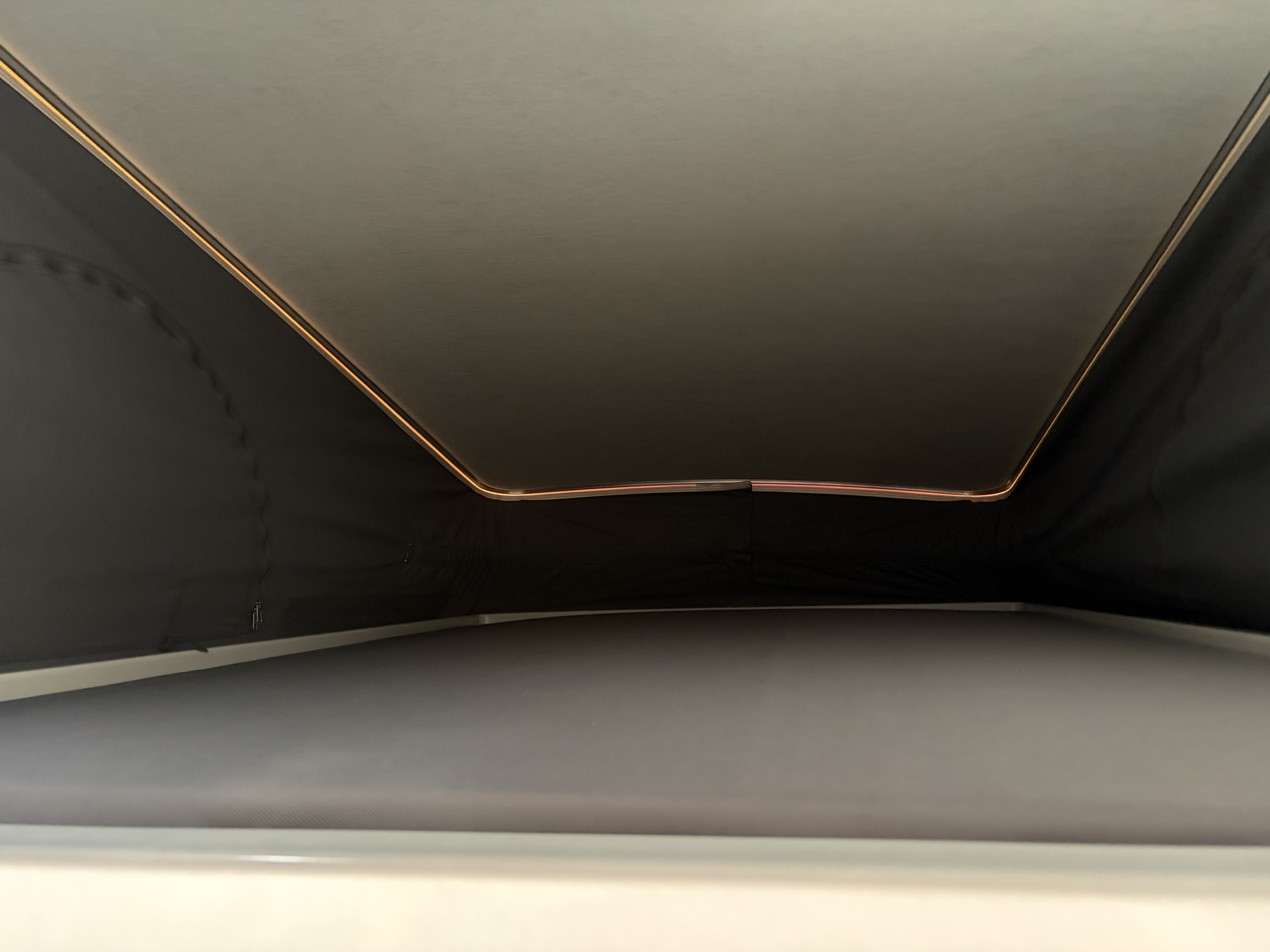 RV rental: Pop-top camper's cozy elevated sleeping area with ambient LED lighting and dark fabric walls.. Winnebago Solis 2023