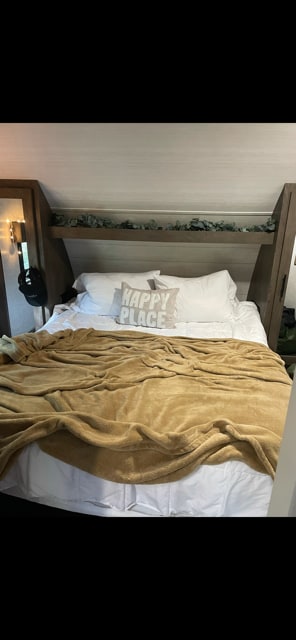 Cozy RV rental bedroom featuring a comfy bed with a "HAPPY PLACE" pillow & decorative greenery above the headboard.. Forest River Salem Cruise Lite 2020