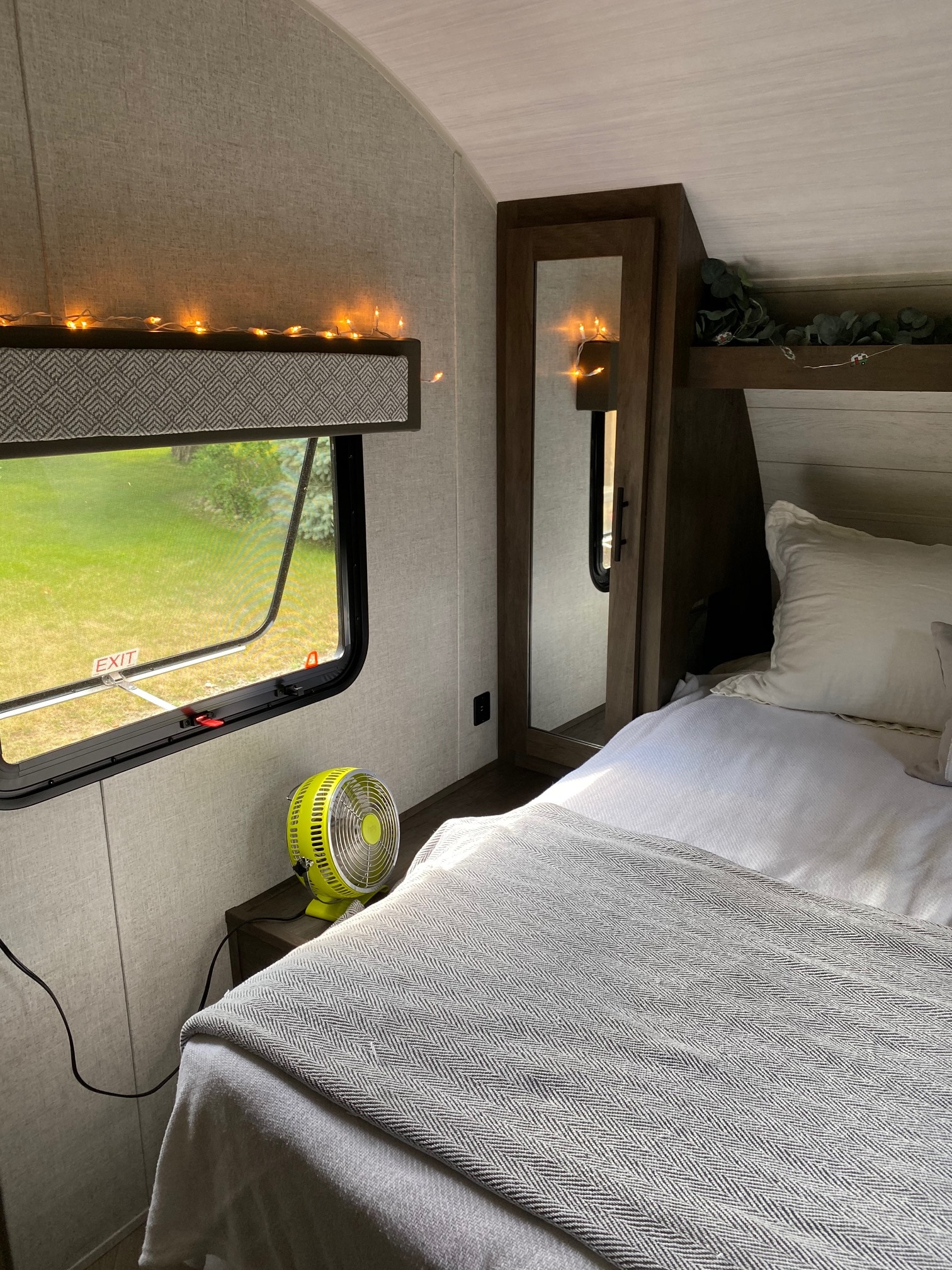 Cozy RV rental bedroom in a travel trailer with string lights, an open window, a fan, and comfy bedding.. Forest River Salem Cruise Lite 2020