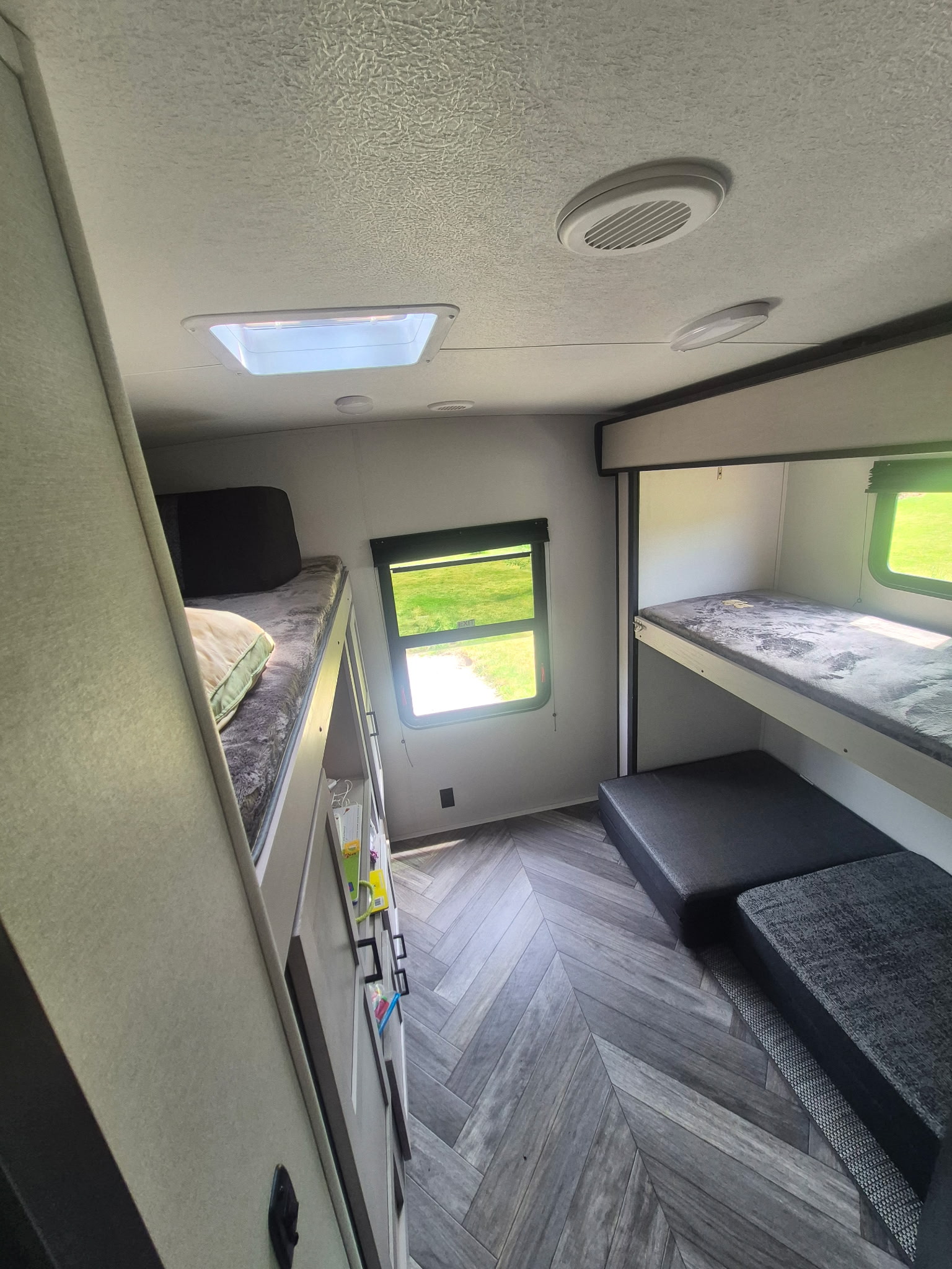 RV rental: Cozy camper interior featuring multiple bunk beds, skylight, and stylish herringbone flooring for family travel.. Heartland RVs Mallard 2024