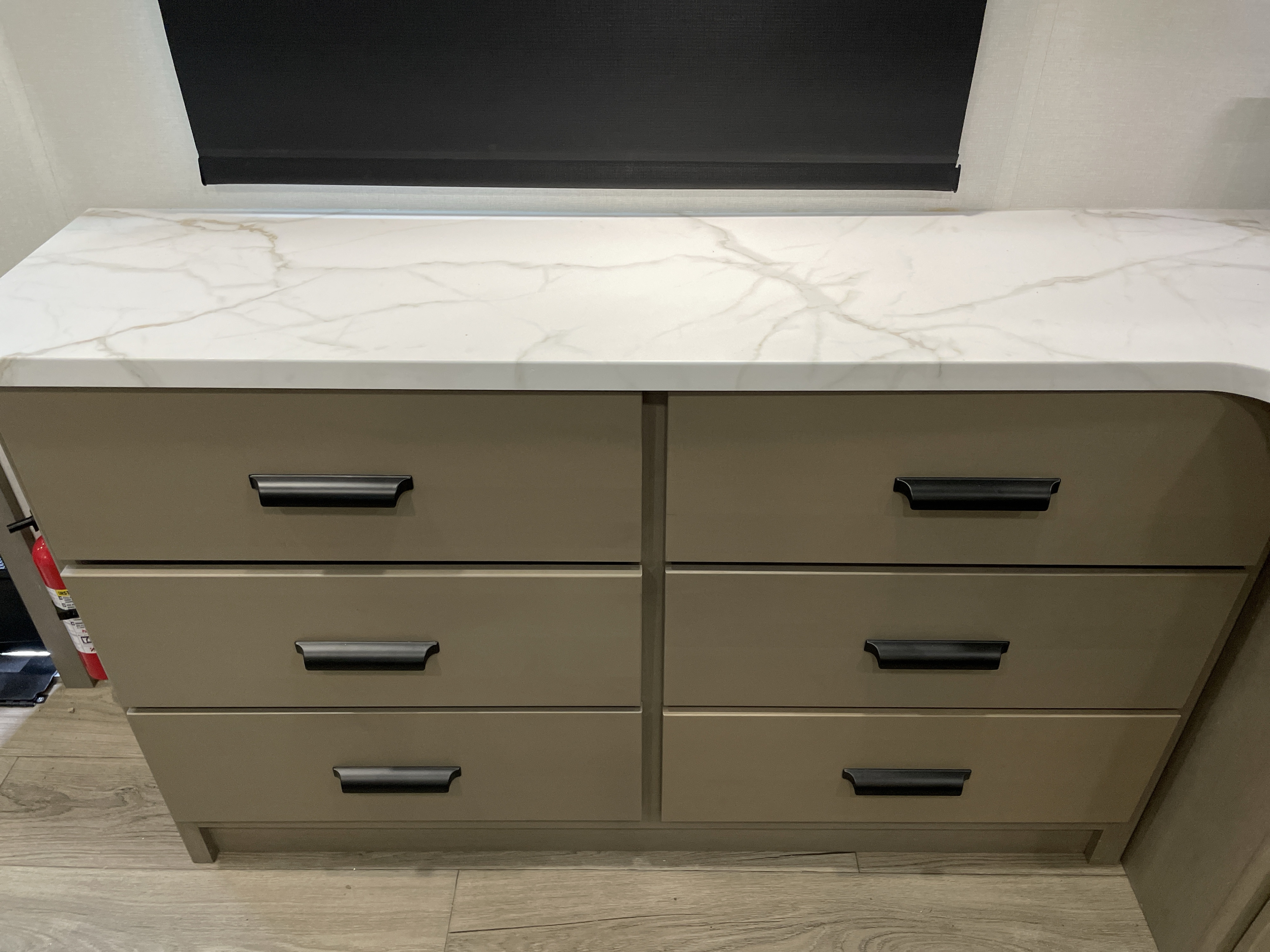 Modern RV rental storage: sleek taupe drawers with black handles, topped by a marble-look counter, offering ample space.. Grand Design Reflection 100 2026