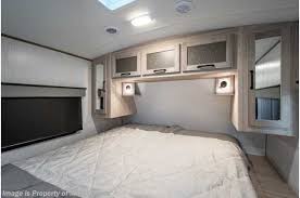 Spacious RV rental bedroom with a queen bed, modern cabinetry, and lighting, offering comfortable sleeping for your travels.. Twilight RVS Signature 2022