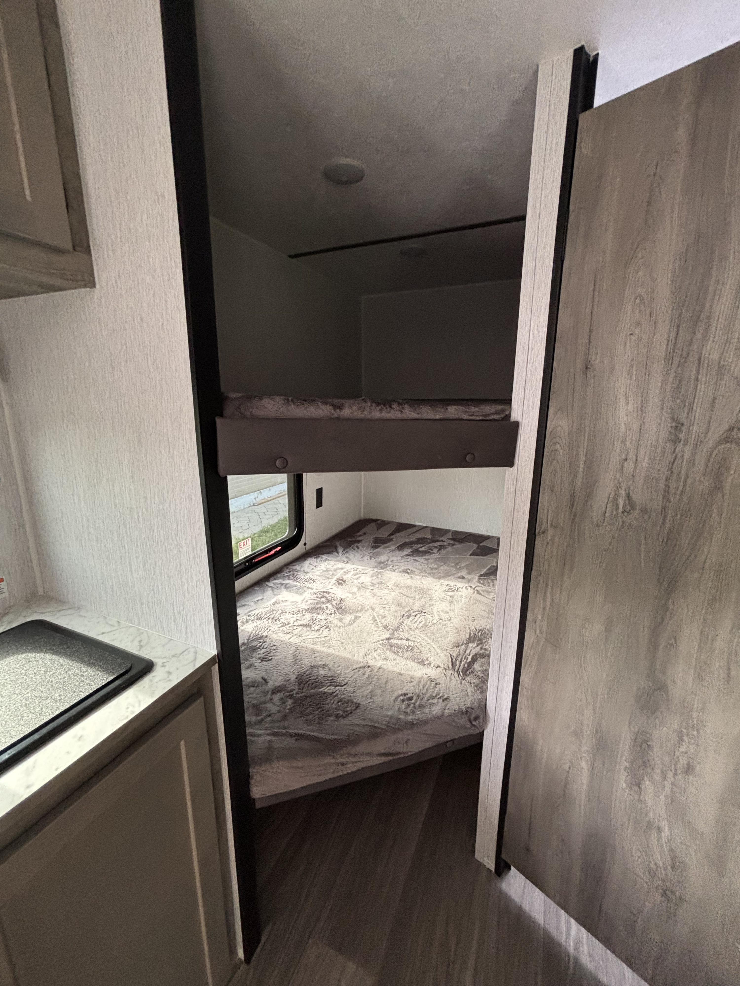 RV rental interior with bunk beds, compact kitchen area, perfect for family adventures in this cozy camper space.. Sunset Park RV Sun Lite LTD 2026