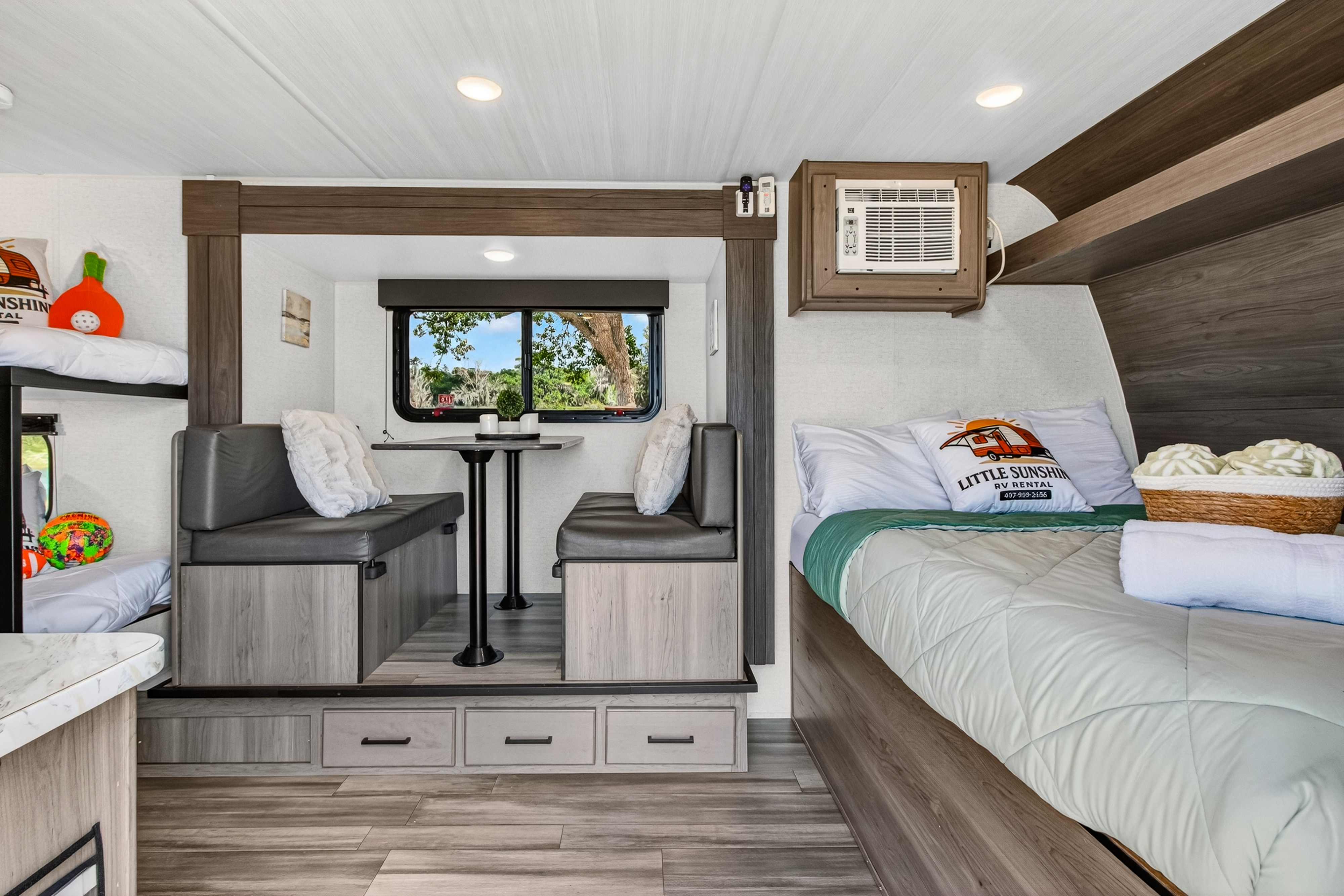 Inside a modern RV rental: a comfortable dinette, bed, bunk beds, and scenic window. Your perfect road trip awaits!. Keystone RV Hideout Sport 2024