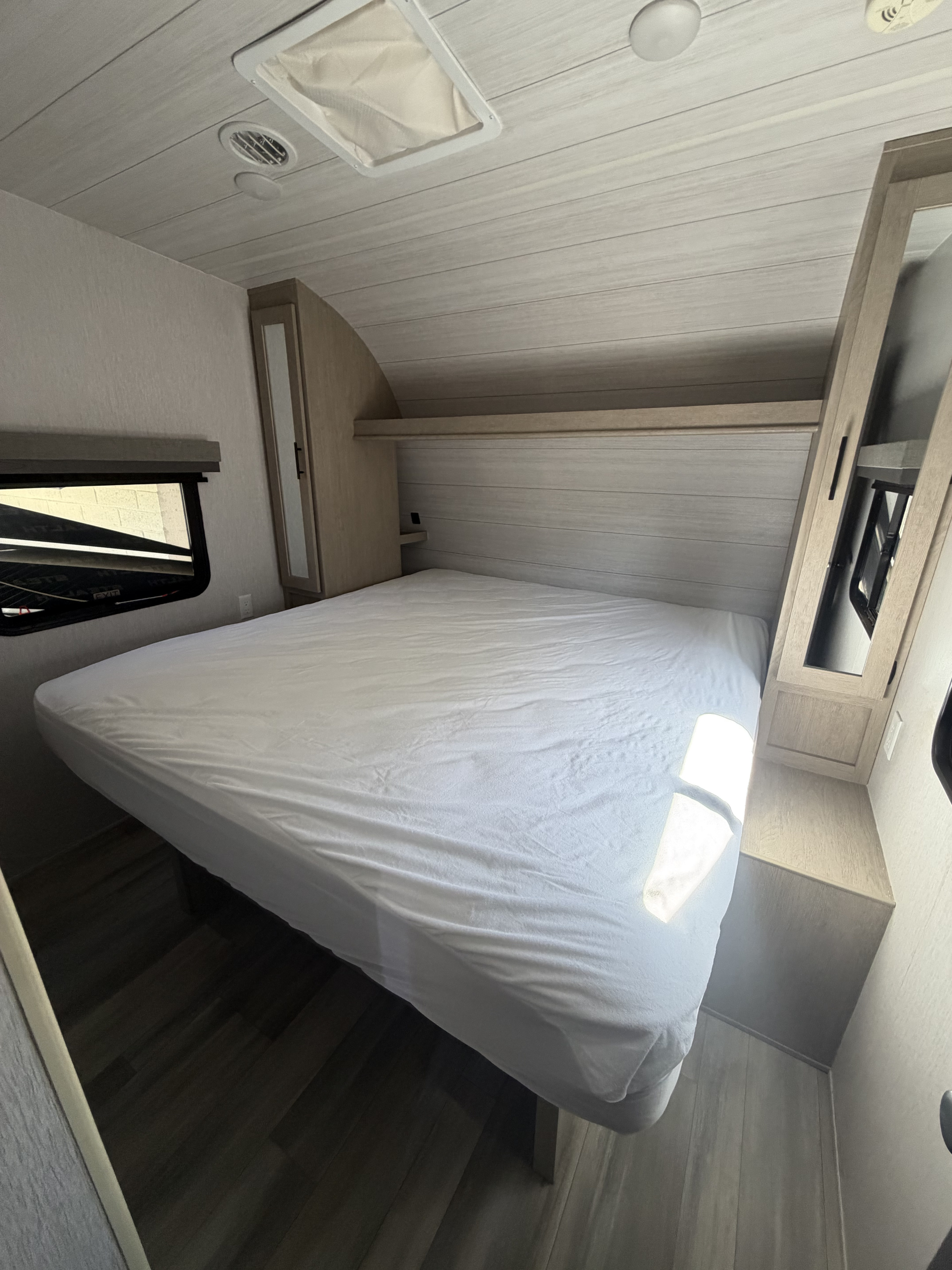 Comfortable RV rental bedroom with a spacious bed, ample storage, and natural light. Perfect for your next adventure.. Forest River Stealth 2023