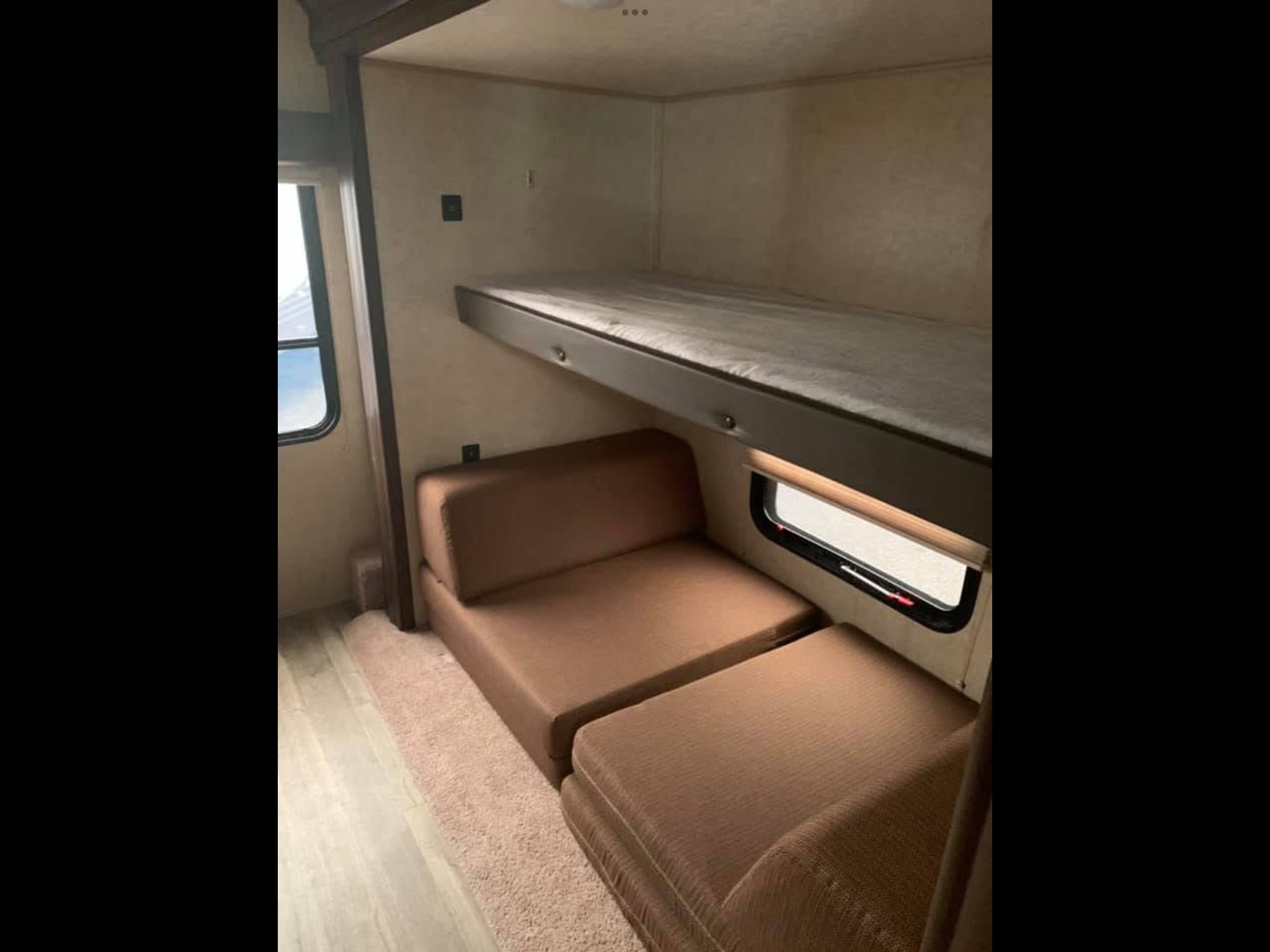 RV rental: Interior showing a spacious bunk bed above a plush, fold-out sofa next to a window, offering flexible sleeping.. Forest River Cherokee 2018