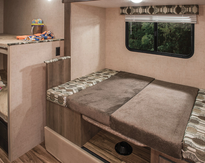 Explore this RV rental's cozy interior: bunk beds & a dinette bed with a scenic window view. Ideal for family camping trips.. KZ Sportsmen Classic 181BH 2018
