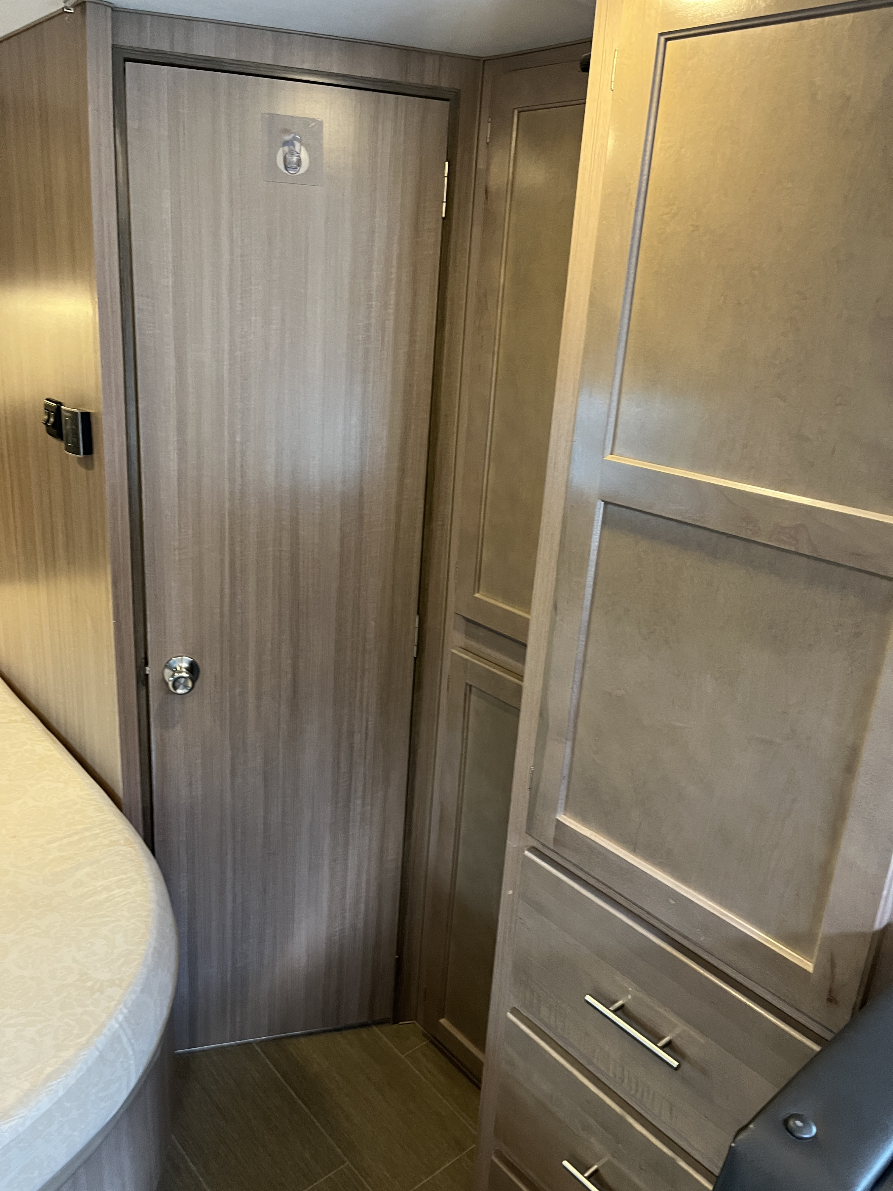 Practical RV rental interior with a wood door, convenient storage cabinets, and a compact design for travelers.. Adventurer 23 RB 2021