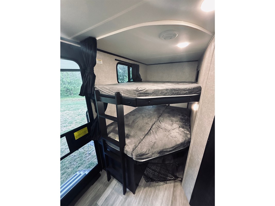 RV rental with comfy bunk beds, ideal for maximizing sleeping space in a compact camper interior for travelers.. Jayco Jay Feather 2022
