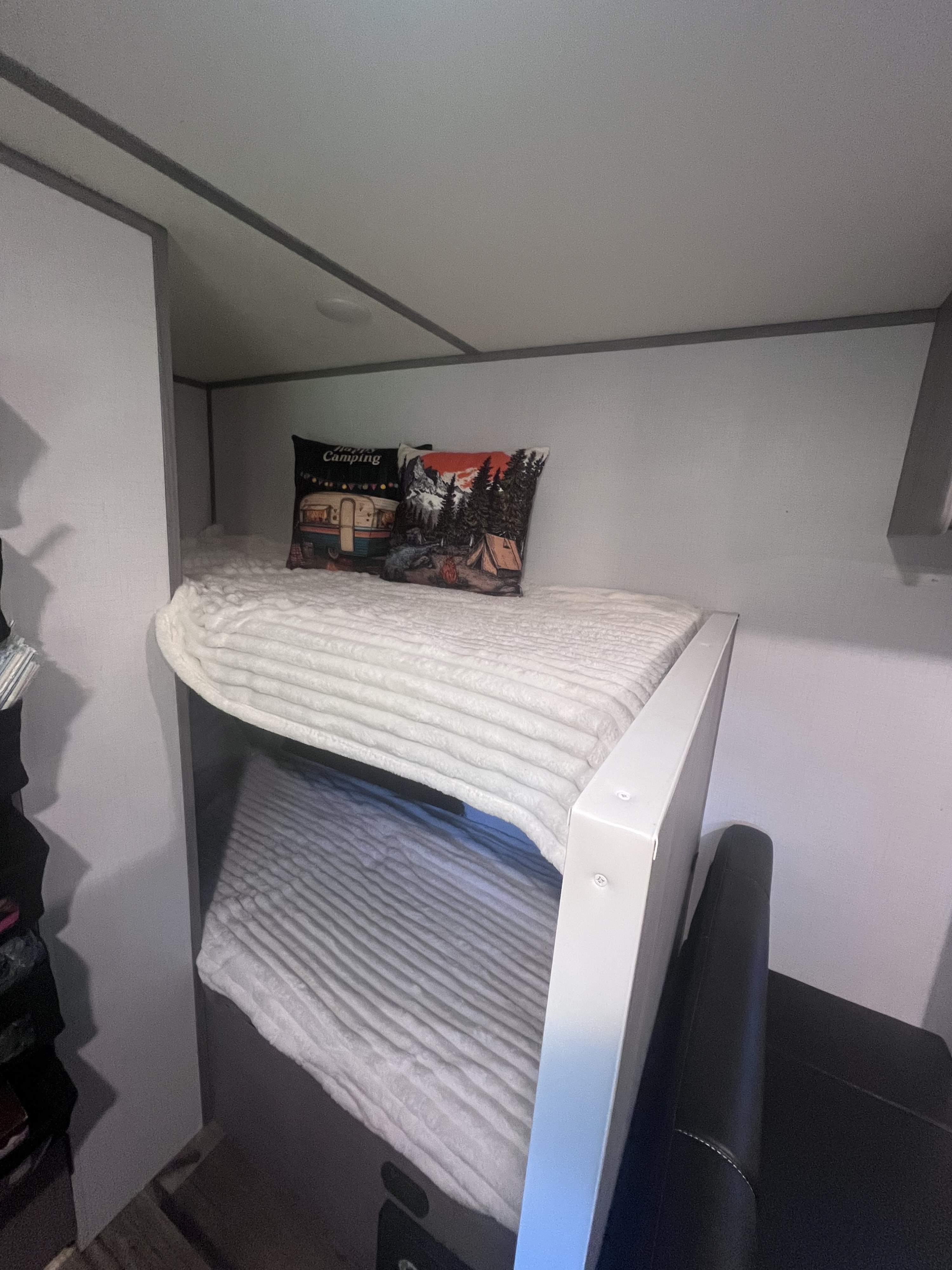 Cozy rv rental bunk beds with soft blankets and camping pillows, ready for adventure.. Keystone RV Coleman Lantern 17B 2024