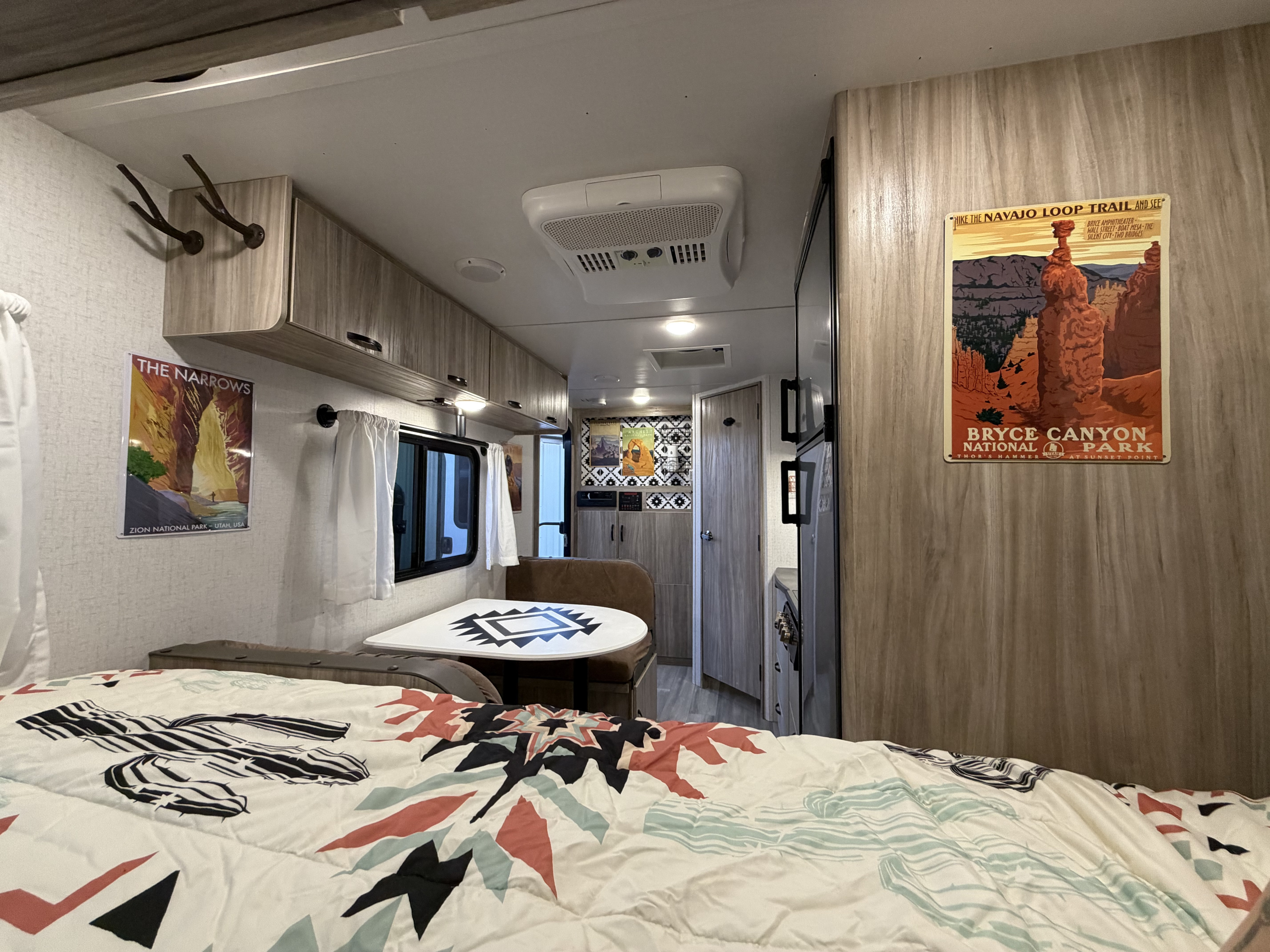 Explore in comfort! This inviting RV rental features a bed, dinette, and travel posters, adorned with Southwestern patterns.. Minnie Micro Minnie 2022