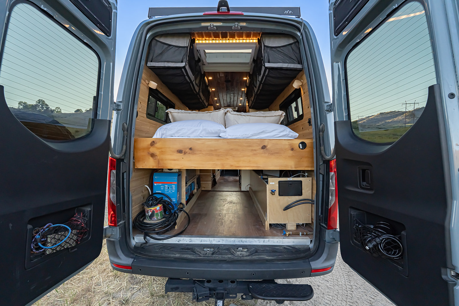 Inside this **rv rental** camper van: an elevated bed, under-bed storage with a power inverter, and coiled gear.. MERCEDES-BENZ SPRINTER 2500 170 WB 2022