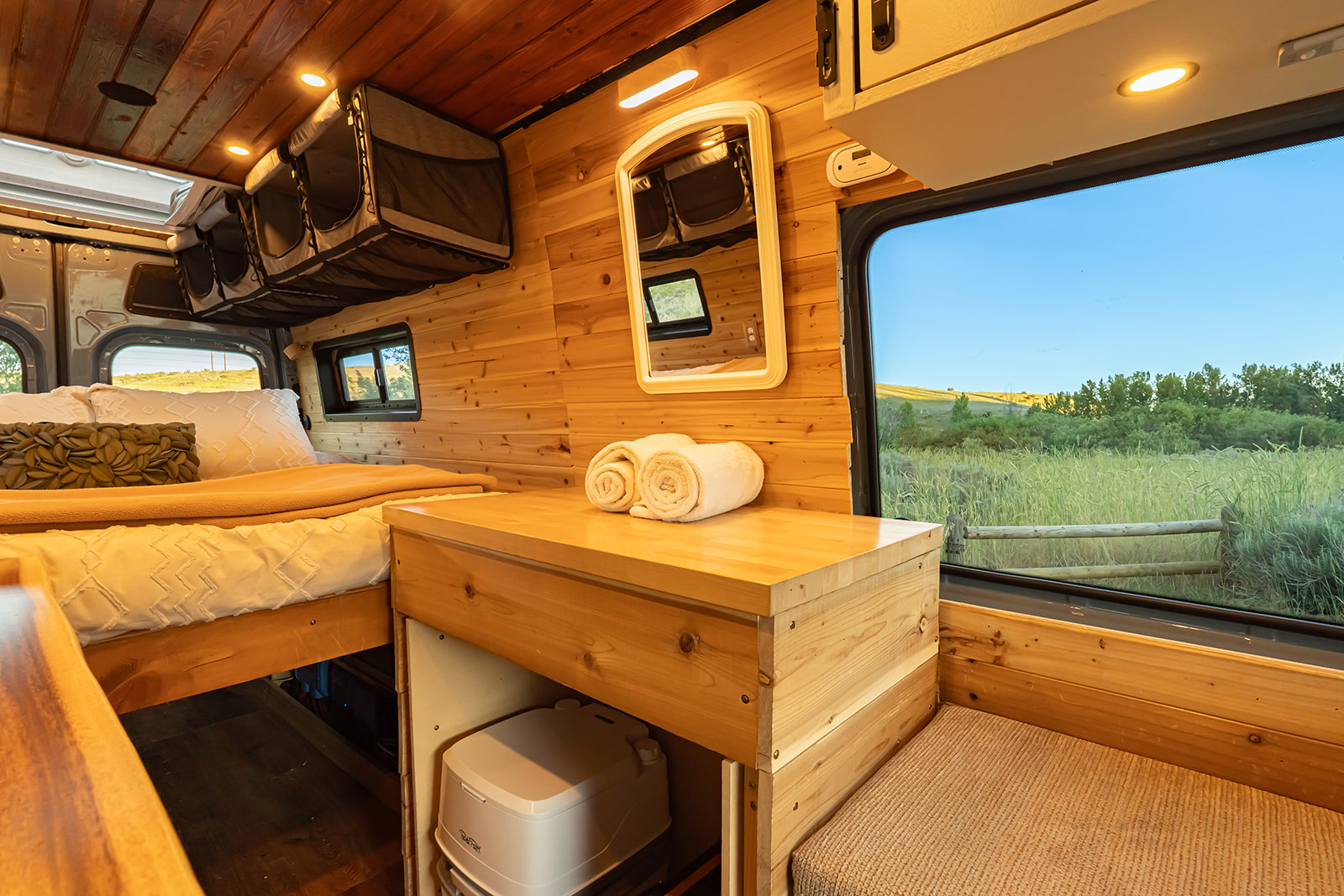 Experience nature in this cozy RV rental with wood interior, comfy bed, storage, portable toilet, and scenic window views.. MERCEDES-BENZ SPRINTER 2500 170 WB 2022