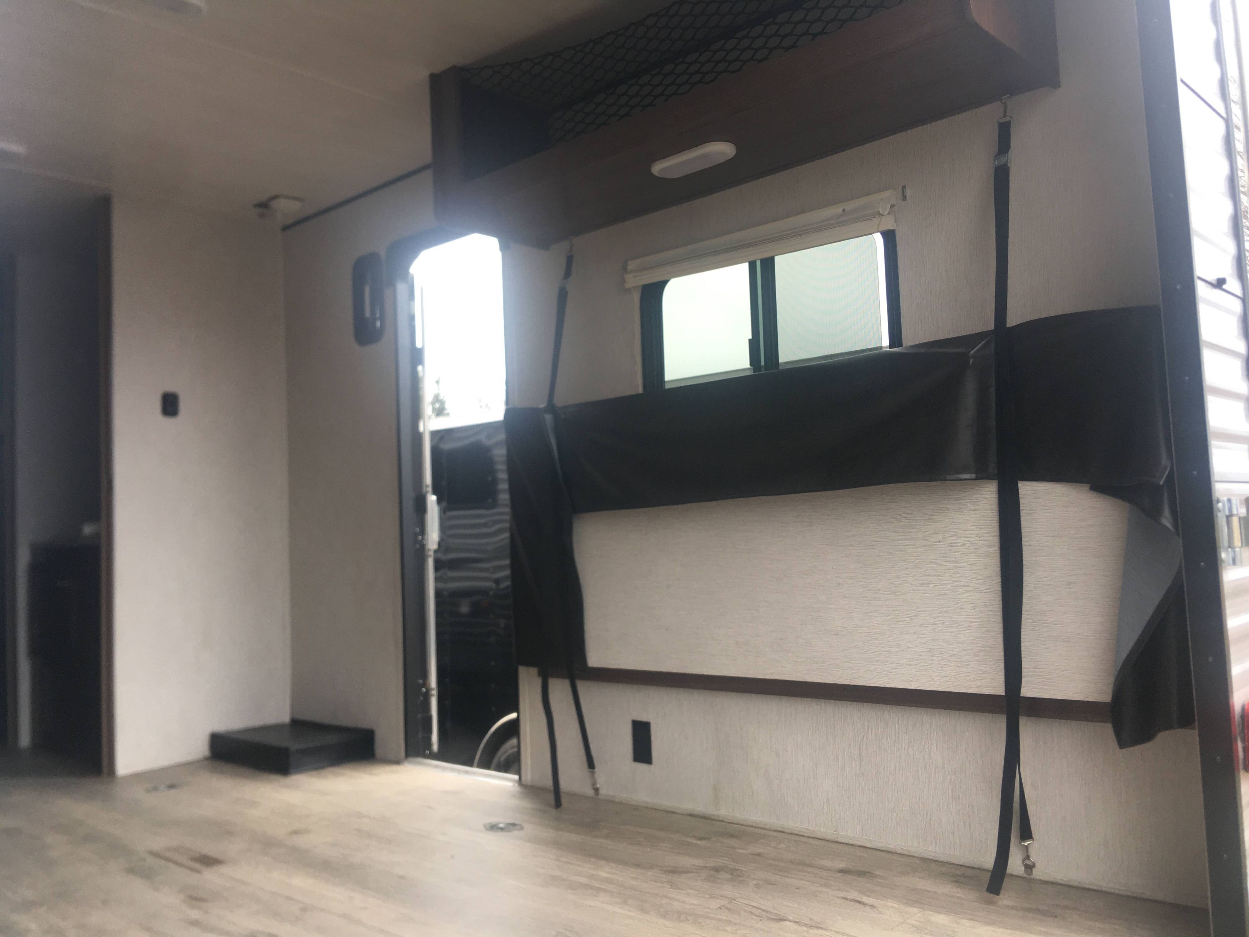 Spacious RV rental interior featuring a fold-down bunk, ample cargo area, and large rear entry for versatile adventures.. Heartland Prowler 2019