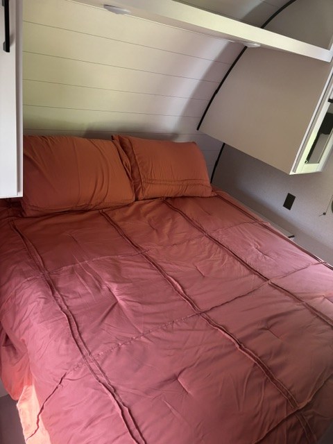 Cozy RV rental bedroom featuring a comfy bed, shiplap walls, and convenient overhead storage.. Jayco Jay Flight SLX 2026