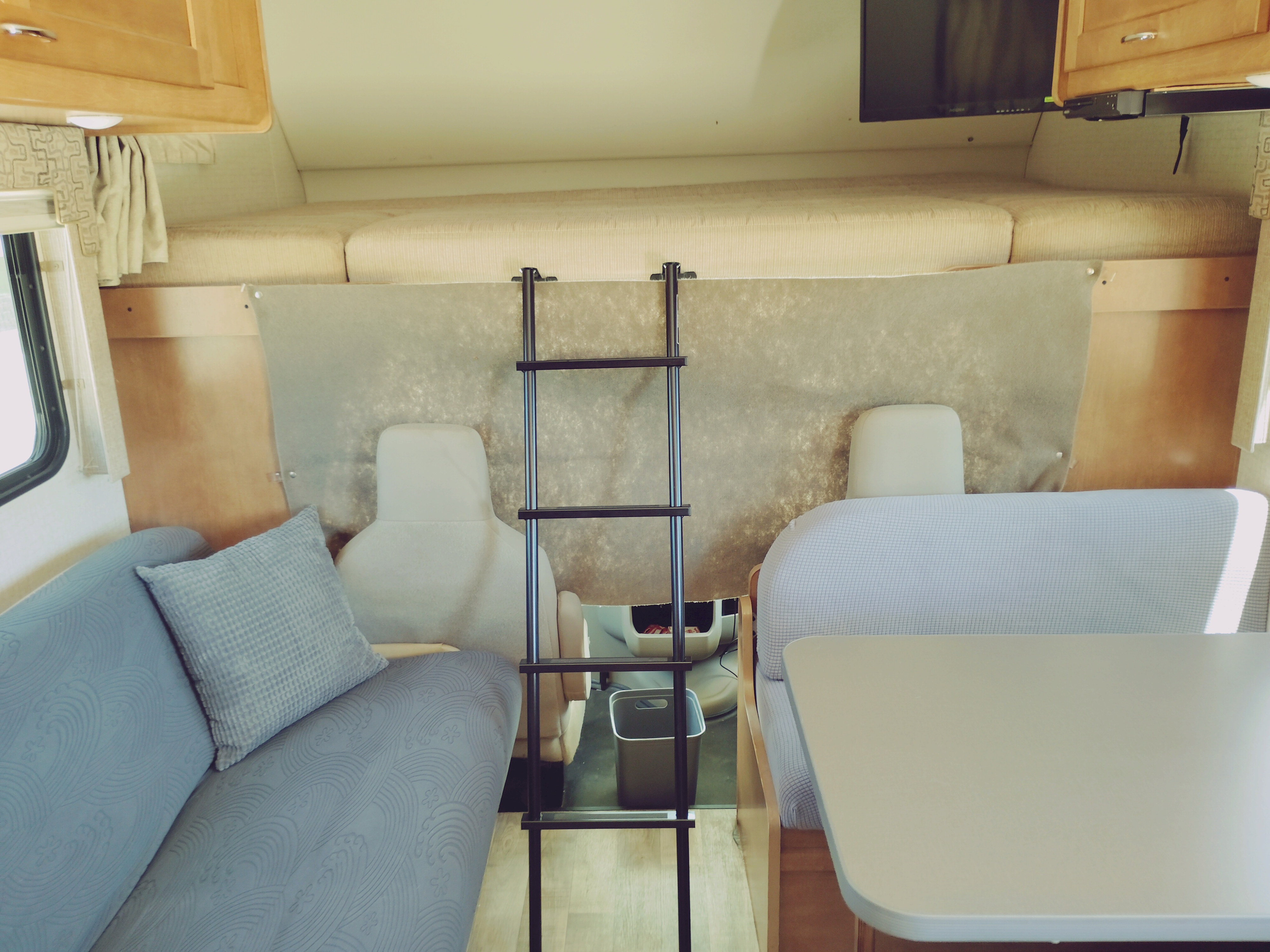 Inside an rv rental: sofa, dining booth, overhead bunk bed with ladder.. Winnebago Minnie Winnie 2017