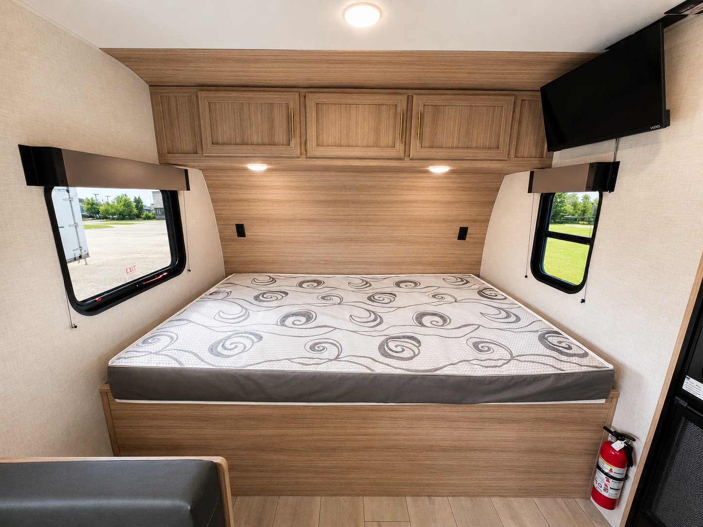 RV rental bedroom with a comfortable bed, large windows, overhead storage, and a TV for a cozy stay.. KZ Sportsmen Classic 2025