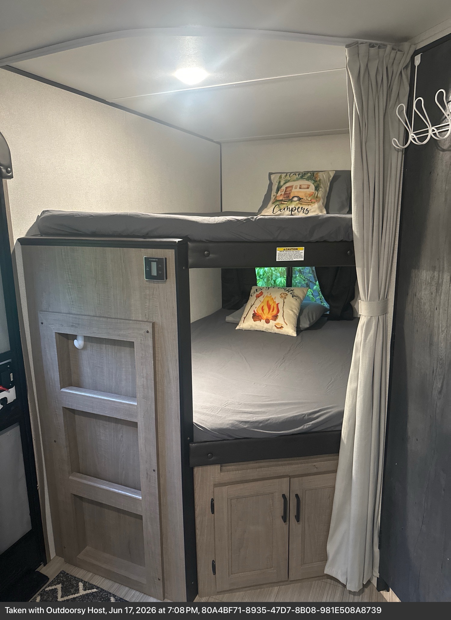 Cozy RV rental bunk beds with camping-themed pillows, a Dometic thermostat, and under-bed storage for a comfortable sleeping area.. Keystone RV Hideout Luxury 2021