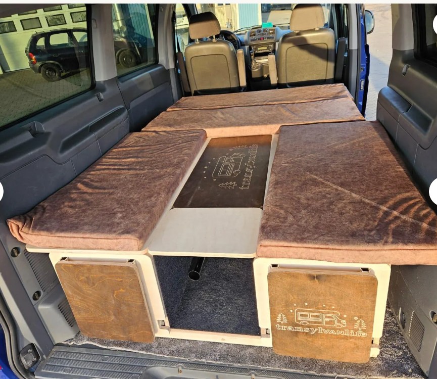 Inside an RV rental camper van: modular bed and storage system with brown cushions, perfect for van life adventures.. Dodge B Van 2015