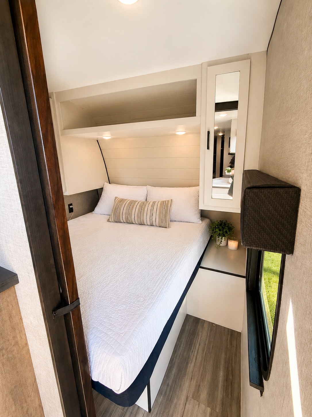 Cozy rv rental bedroom features white bedding, shiplap headboard, and wood-look floors, offering compact comfort.. Jayco Jay Flight SLX 2024