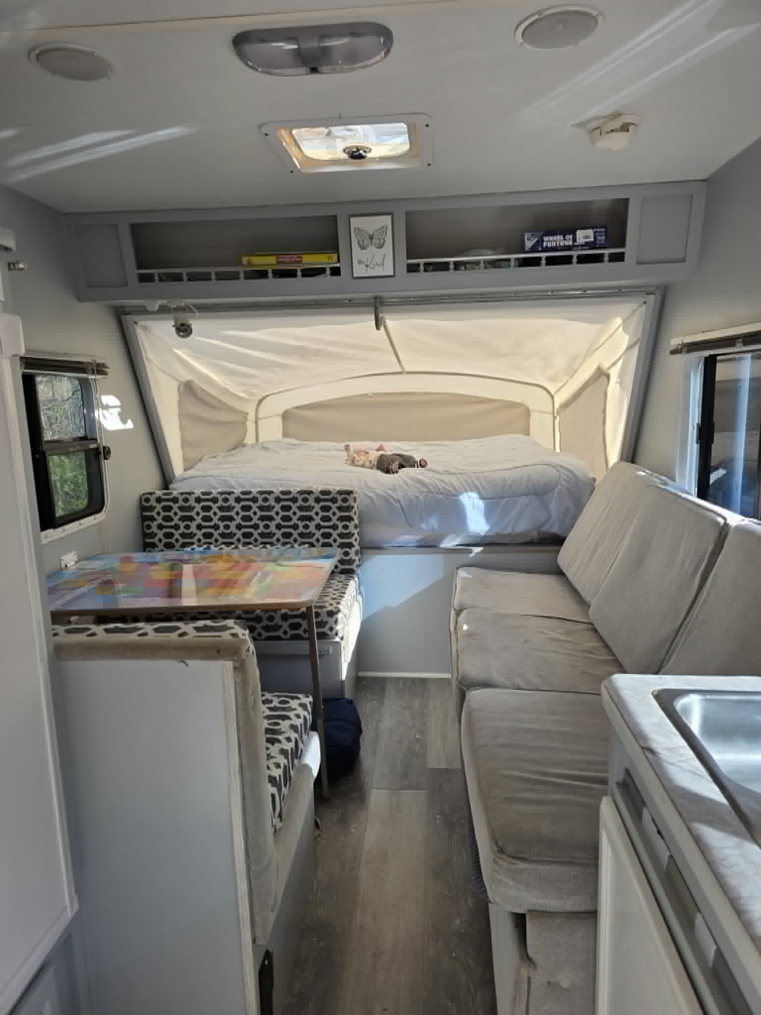 Inside a bright rv rental camper, revealing a comfortable pop-out bed, dinette, and sofa.. R-Vision Trail-Lite Bantam 2003