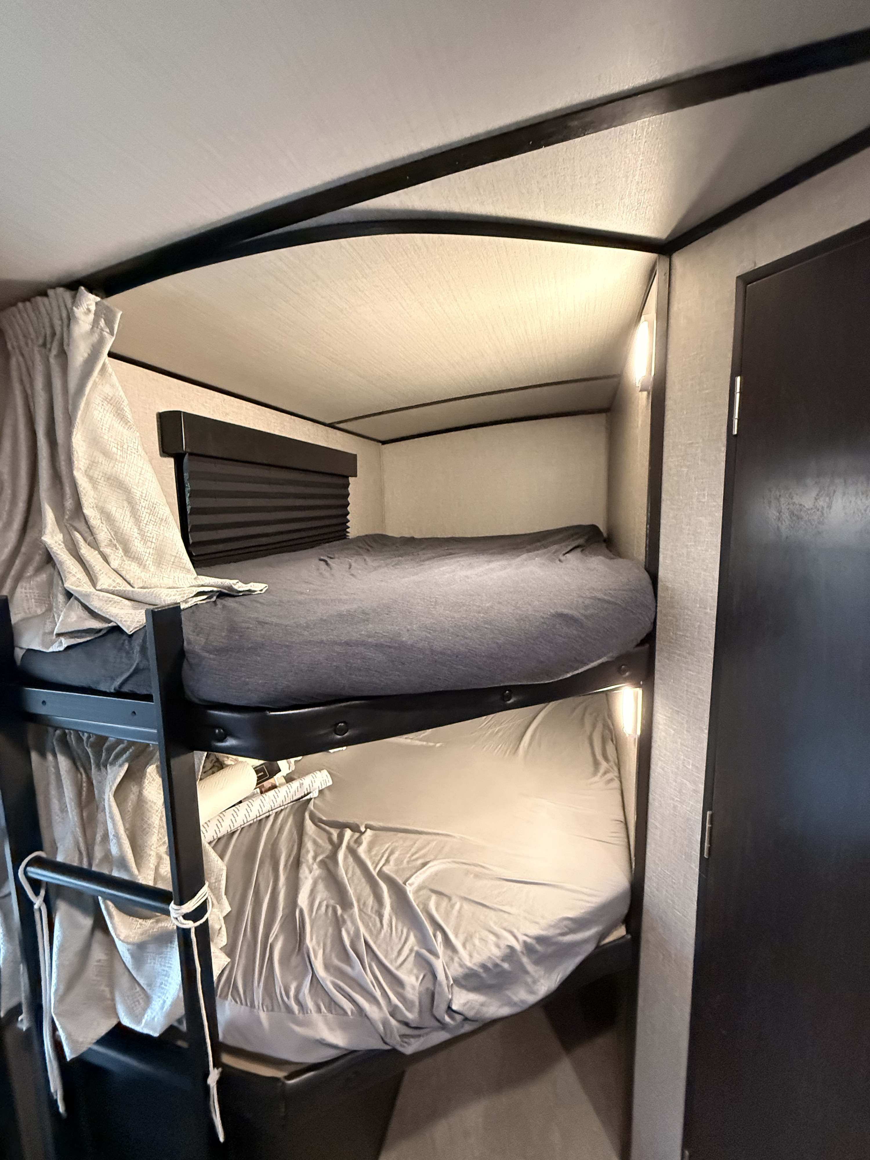 Cozy RV rental bunk beds with grey sheets, individual lights, and blinds. Perfect sleeping quarters for your camper adventure.. Imagine Grand Deigns 2019