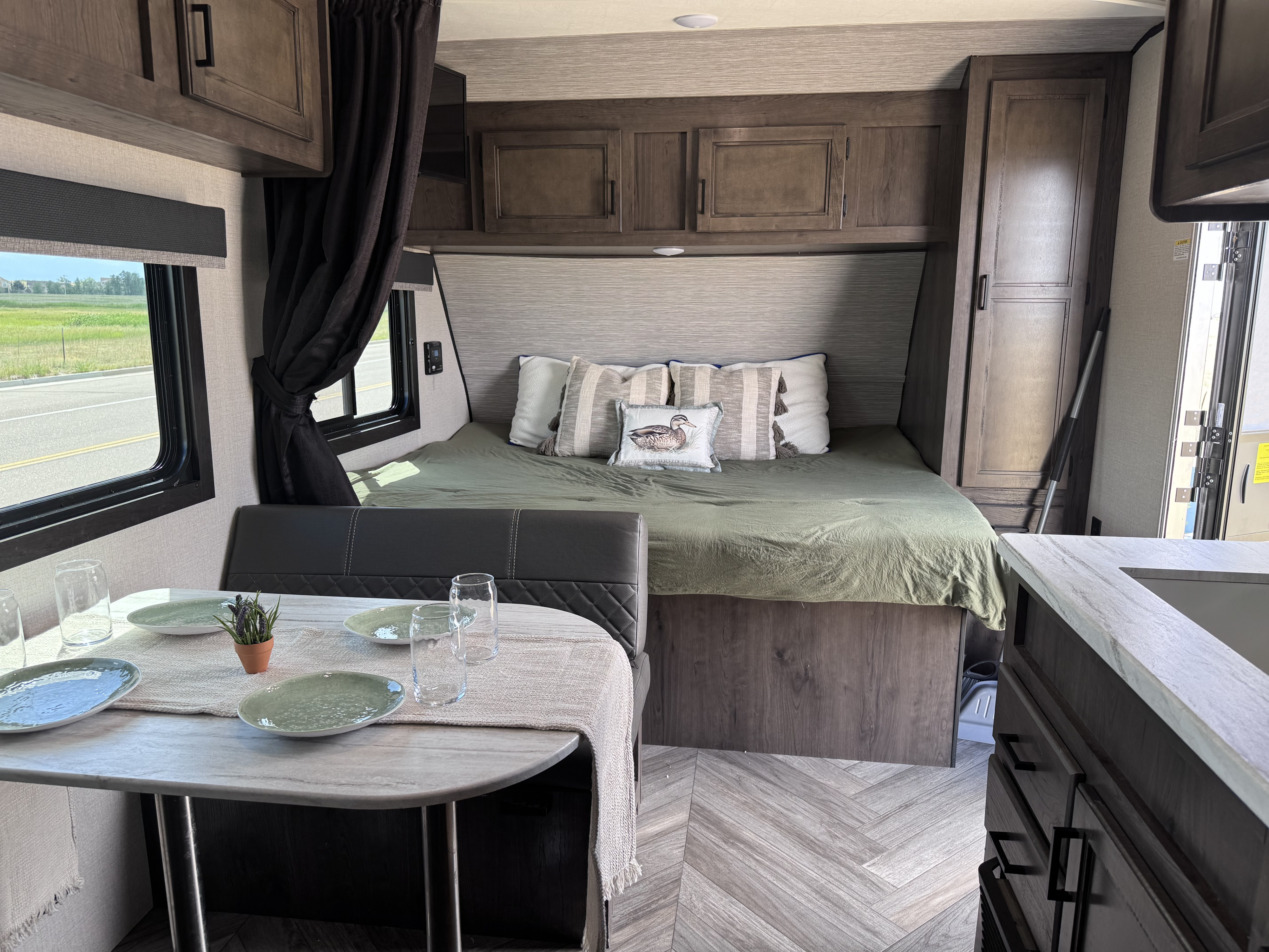 Cozy RV rental interior: A modern bedroom with a bed & storage, plus a dining table set for travelers.. Highland Ridge RV Olympia Sport 2022