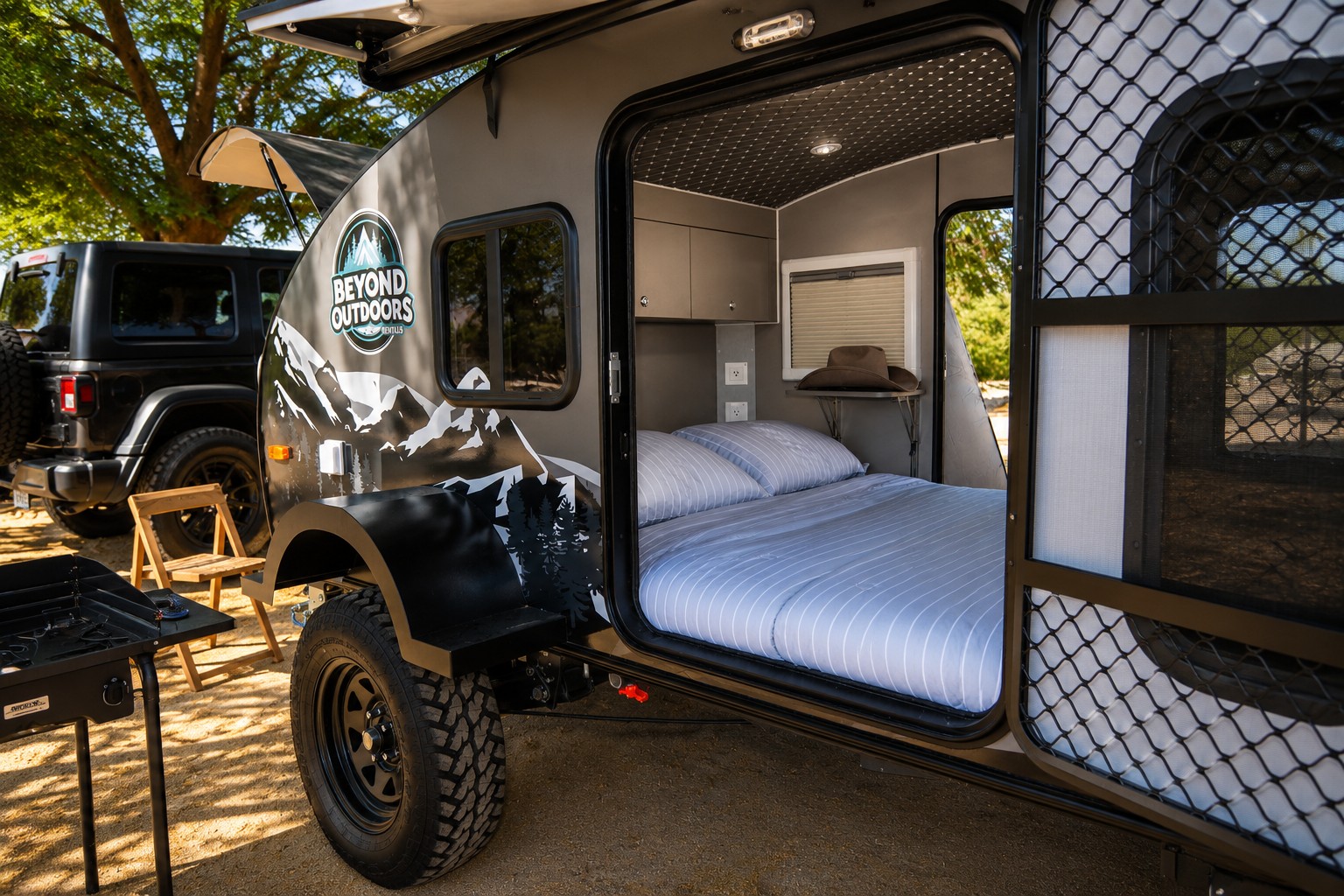 Experience outdoor adventure! This rv rental teardrop camper offers a cozy bed & outdoor stove, parked beside a Jeep for your next camping trip.. Beyond Outdoors MiniGrey 2025