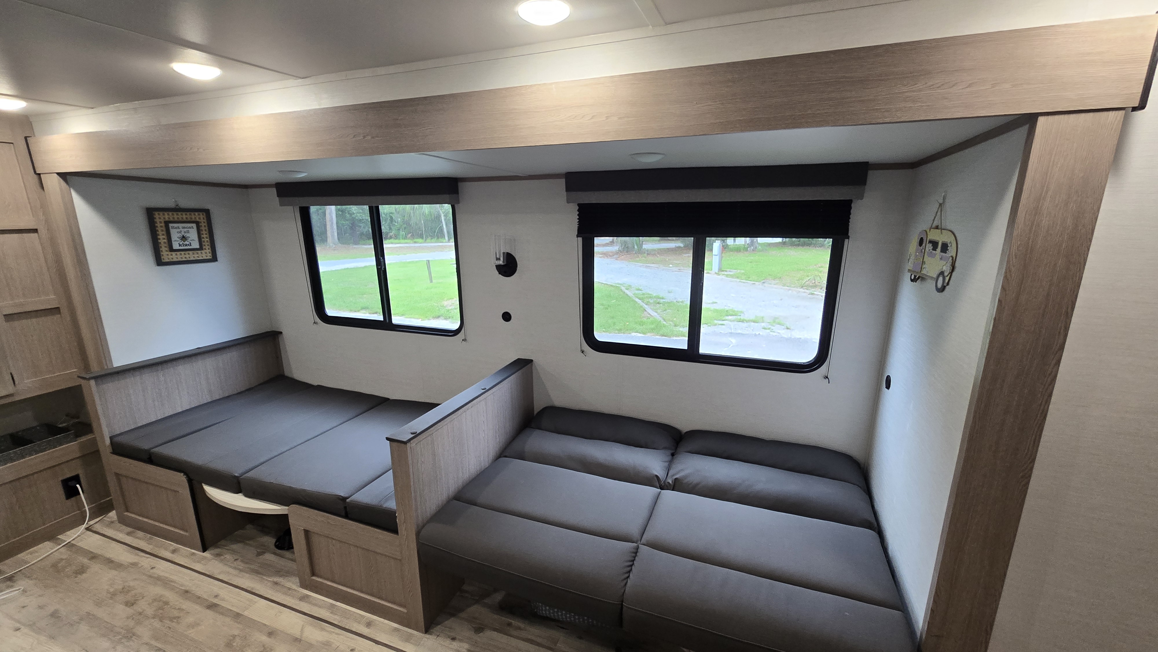 RV rental interior: Dinette benches configured as beds, with windows for natural light. Perfect for travel.. Gulf Stream Ameri-Lite 2025